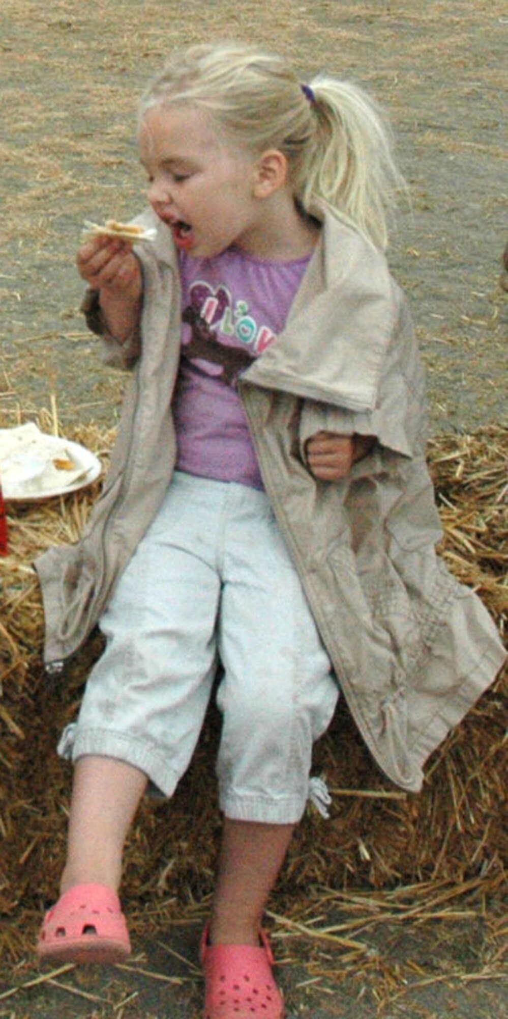 Four-year-old Lily Nemechek gets ready to take a bite of her lunch while sitting on a haystack at the 446th Airlift Wing annual Family Day on Aug. 8, at Heritage Hill, McChord Air Force Base, Wash. Lily's father, Tech. Sgt. Quentin Nemechek, works for the 446th Aircraft Maintenance Squadron. (U.S. Force photo/Tech Sgt. Jake Chappelle).