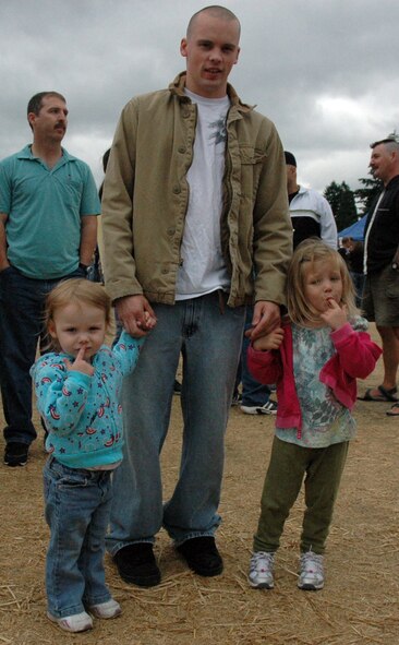 Camille Peck (from left to right),  waits in line for hotdogs and drinks with her father Senior Airman Scot Peck, 446th Maintenance Squadron, and her cousin, Kennedy Barrow, at the 446th Airlift Wing annual Family Day on Aug. 8, at Heritage Hill, McChord Air Force Base, Wash. (U.S. Force photo/Tech Sgt. Jake Chappelle).