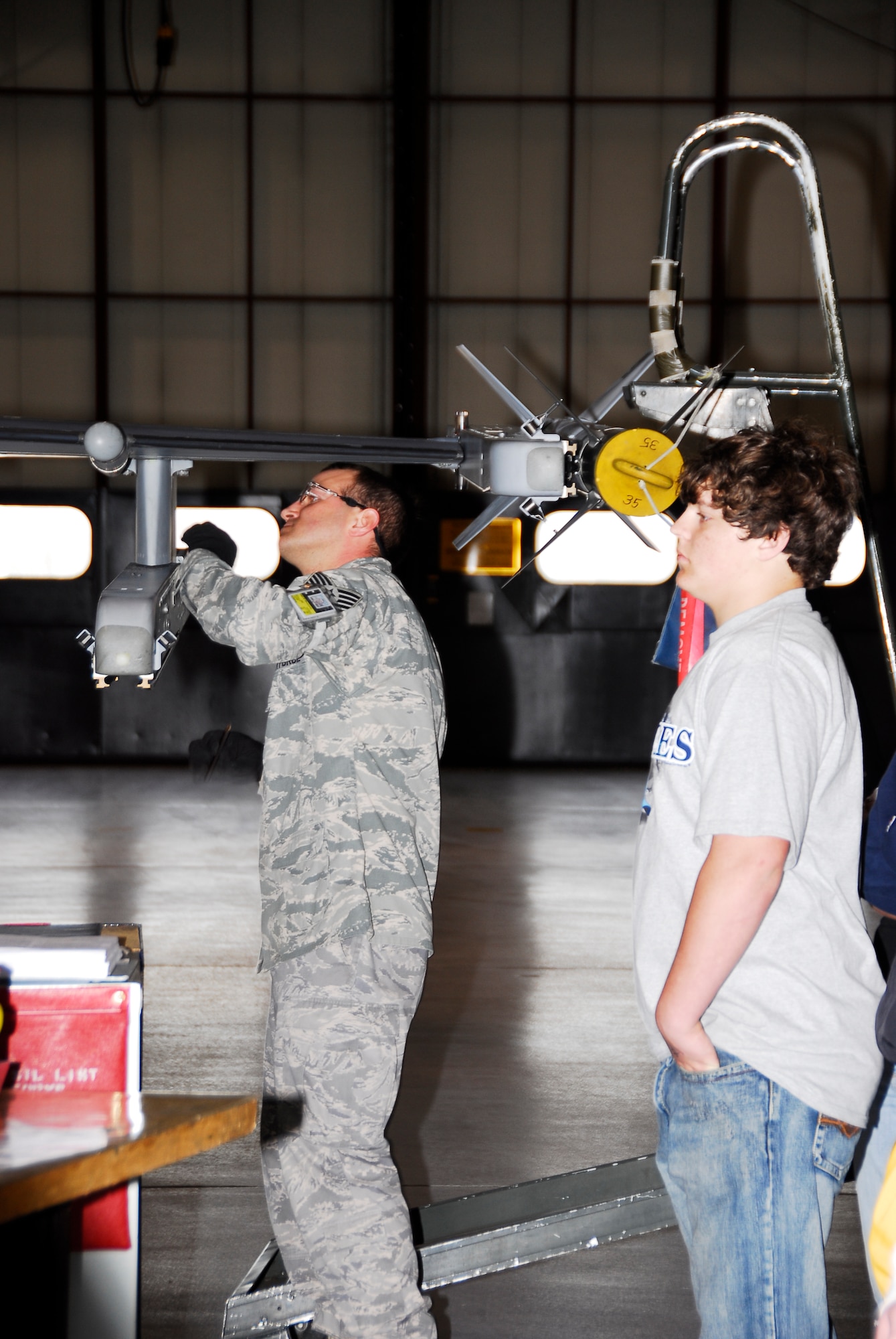 SIOUX FALLS -- Barry Wood, a sophmore at Alcester-Hudson High School, observes Tech. Sgt. Cory Jorgensen as he works on an F-16 aircraft. Jorgensen is a maintenance job controller with the 114th Avionics section.  (U.S. Air Force Photo by Master Sgt. Nancy Ausland)