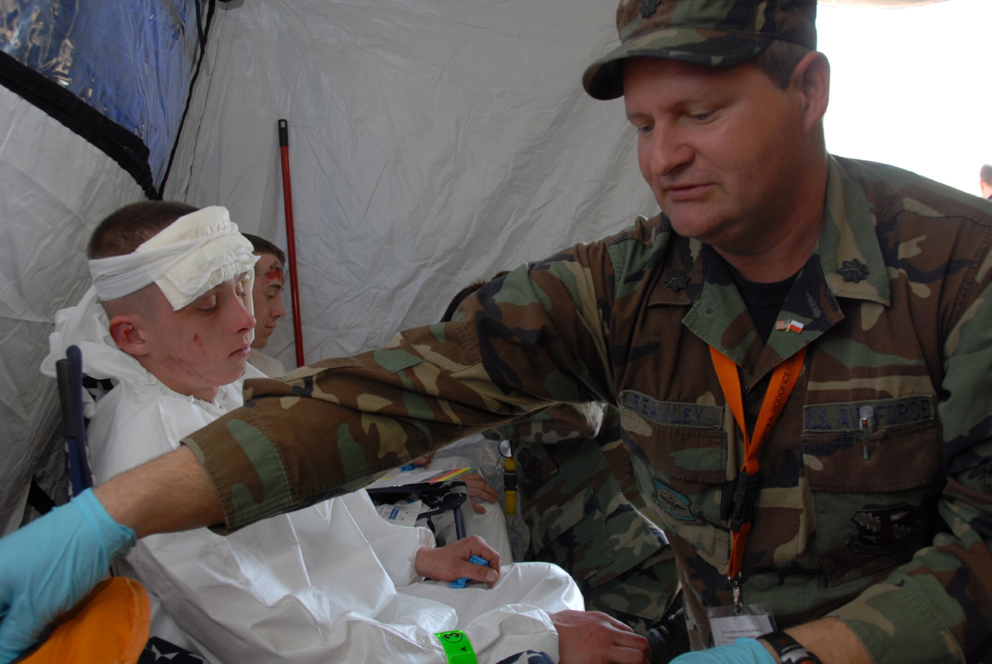 Lt. Col. Craig Reavley simulates providing medical care to a Polish military volunteer.  The activities took place on April 24, 2009 as part of Exercise Eskulap '09 at a former Soviet military base near Warsaw, Poland.