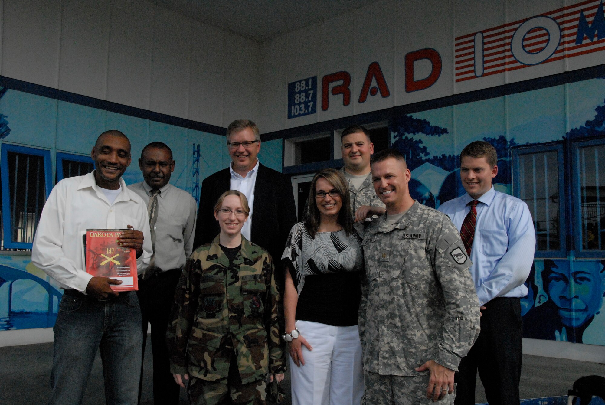 Master Sgt. Chris Stewart and Staff Sgt. Kristi Niedert, 114th Fighter Wing Public Affairs, pose with Maj. Brendan Murphy, S.D. State Public Affairs Officer and other members of the S.D. press  in front of Radio 10 in Paramaribo, Suriname July 1.