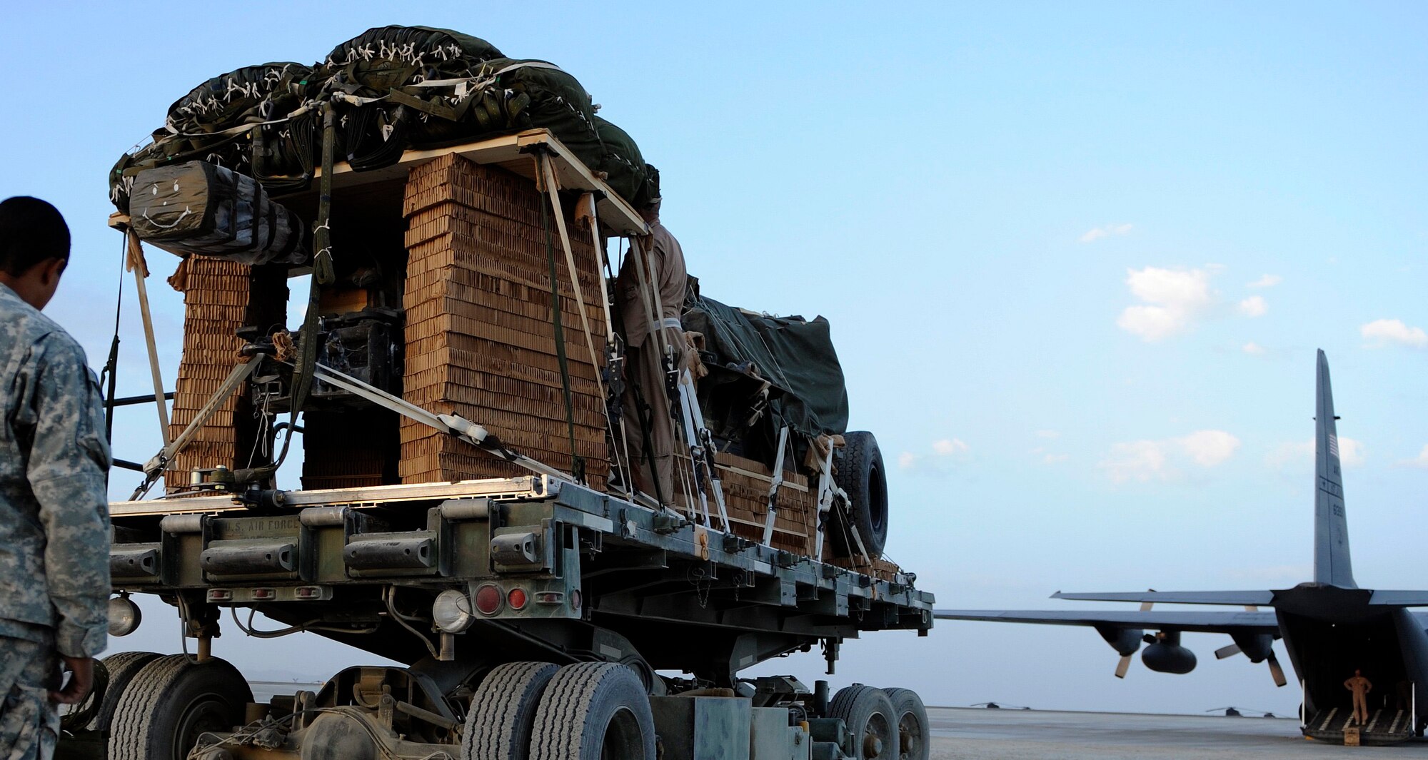 BAGRAM AIRFIELD, Afghanistan - A joint Army-Air Force team loads a ten-ton pallet aboard a C-130H Hercules aircraft. The Total Force aicrew from the 774th Expeditionary Airlift Squadron delivered an M198 howitzer artillery piece to a forward operating base in Afghanistan Aug. 8, 2009. The 36-foot long cannon will give troops the ability to send high explosive shells at insurgents threatening the peace and security of the Paktika Province. (U.S. Air Force photo by Staff Sgt. Michael B. Keller)