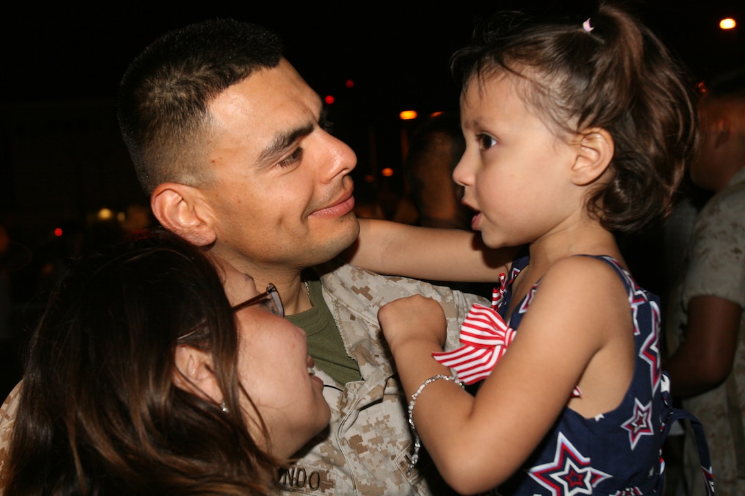 Staff Sgt. Israel Arredondo, an aviation ordnance technician with Marine Heavy Helicopter Squadron 361, holds his daughter Katarina, after arriving at the air station, during his squadron's homecoming, August 9.  (Official U.S. Marine Corps photo by Cpl. Christopher O'Quin)(Released)