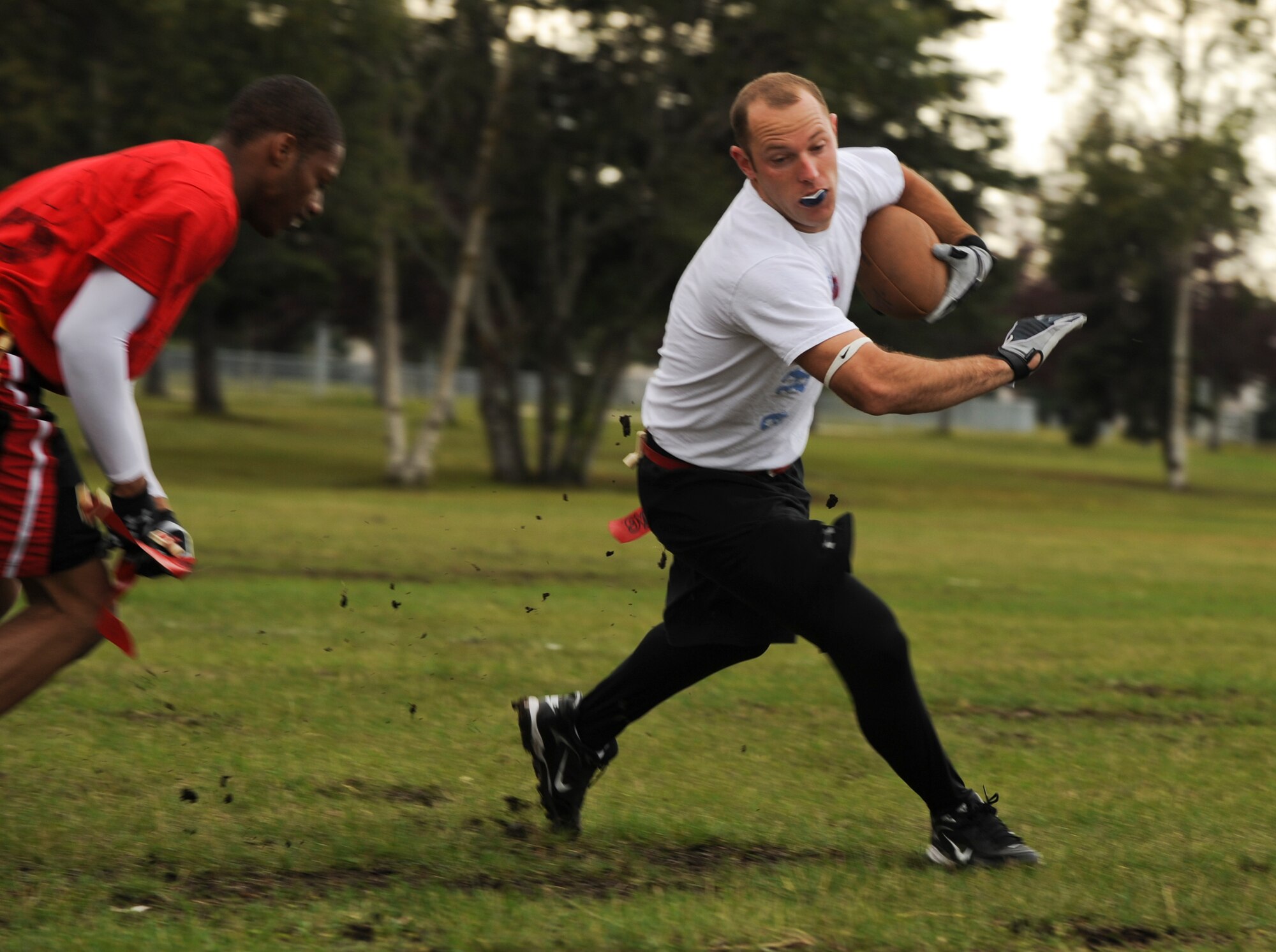 ELMENDORF AIR FORCE BASE, Alaska -- Alan Austin tries to run away from a defender during the intramural flag football game Aug. 6. This was the season's first football game. The 3rd LRS team beat the 703rd Aircraft Maintenance Squadron team 27-14. Austin is an airman first class with the 3rd LRS team. (U.S. Air Force photo/Senior Airman David Carbajal)