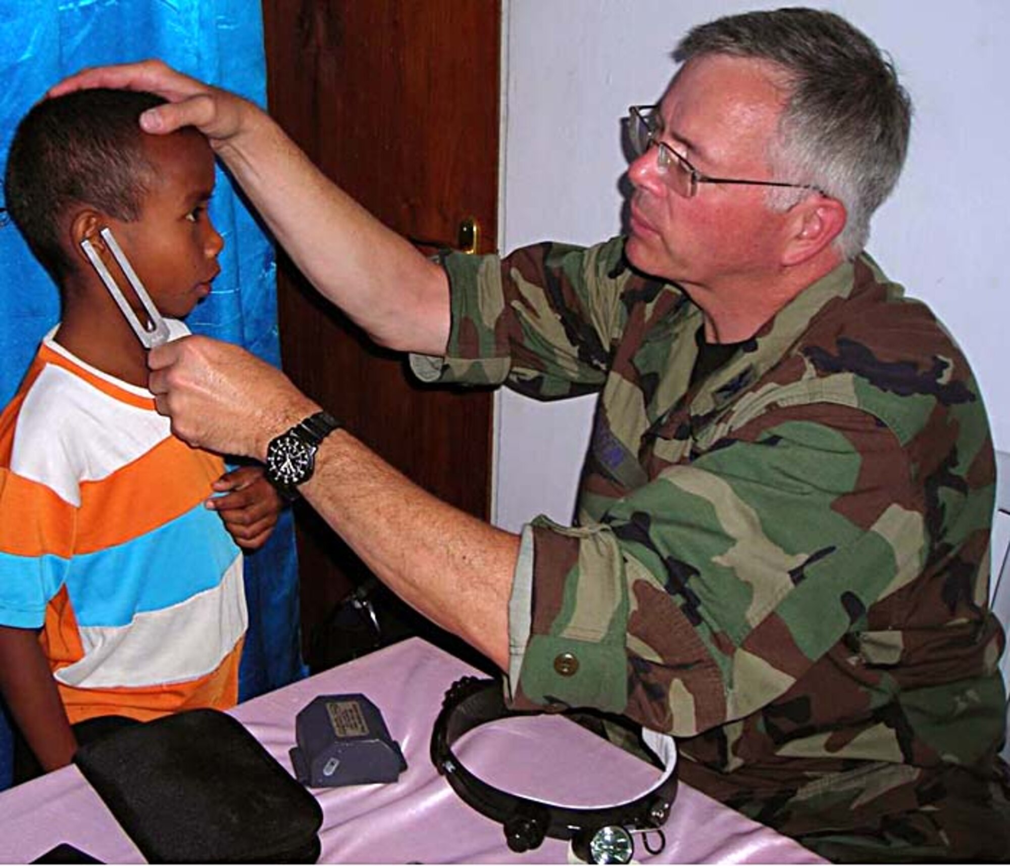 A little Timorese boy gets his hearing checked by Col. Paul Abson, operations flight commander, 446th Aeromedical Staging Squadron, McChord Air Force Base, Wash.  Colonel Abson and a team of Reserve medical experts were deployed to West Timor July 16-23, in support of the continuing humanitarian mission of Pacific Angel. (Courtesy photo)