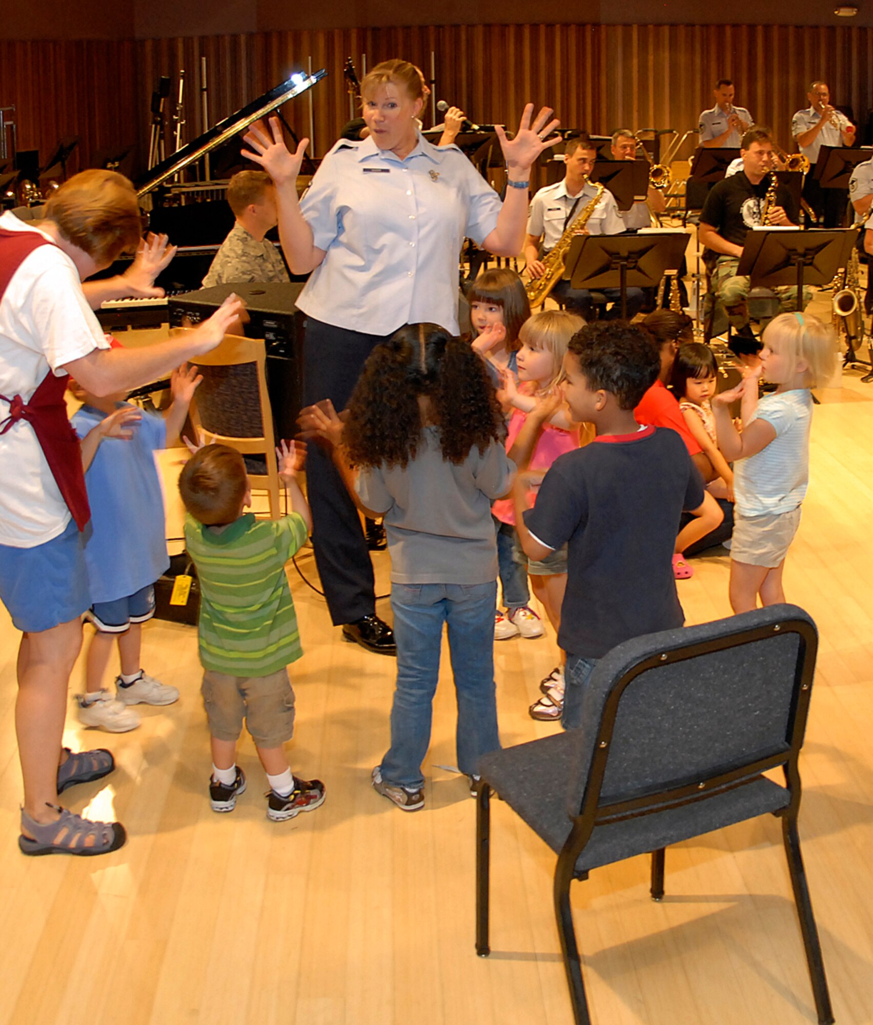 Master Sgt. Cheryl Sizer engages with children enrolled at the Child Development Center on Peterson Air Force Base, Colo., for fun with live music at the U.S. Air Force Academy Band's facility on Peterson AFB. Among the children in attendance was Sergeant Sizer?s daughter, Sophia, to her immediate left. (U.S. Air Force photo/Larry Hulst)