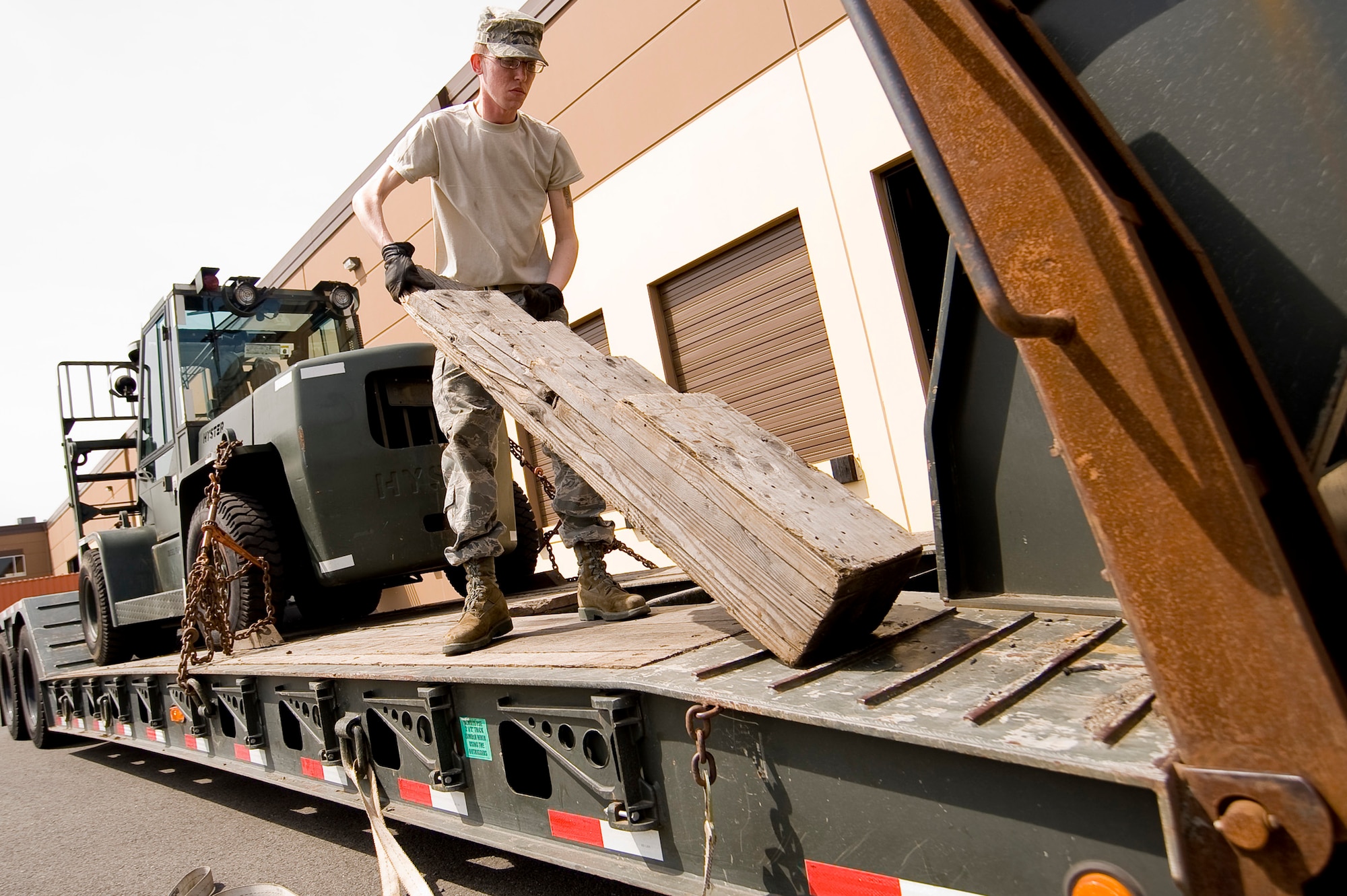 Airman First Class Matthew Zorich, 62nd LRS, removes dunnage from the bed of a trailer while preparing to deliver a forklift to a local body shop for paint. (U.S. Air Force Photo/Abner Guzman)
