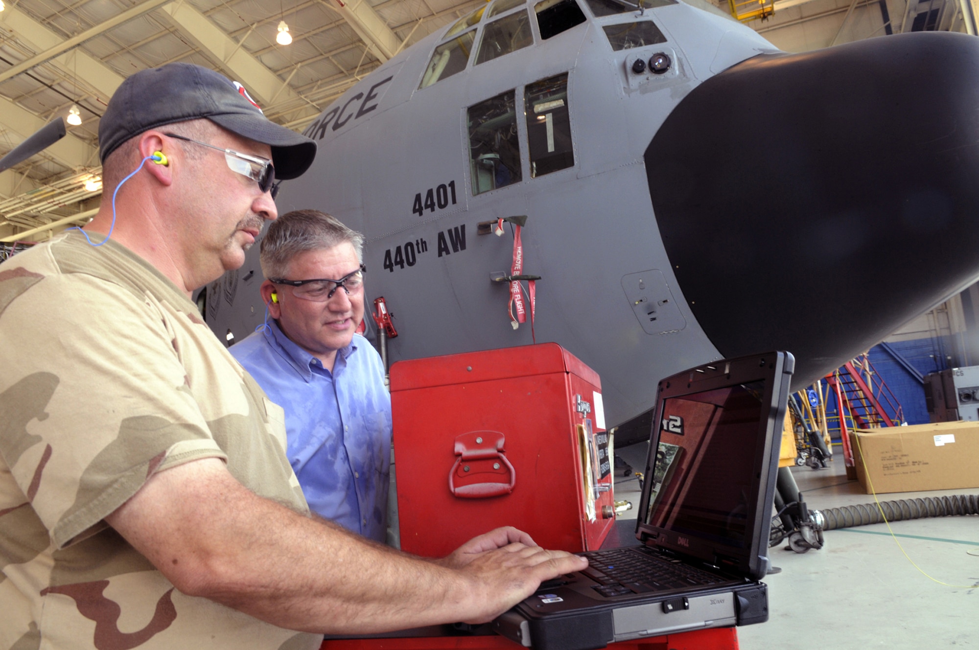 Jim Meyer and Tim Reynolds use e-tools as they work on a C-130 Hercules at Robins Air Force Base, Ga. Mr. Meyer is an aircraft mechanic and Mr. Reynolds is the technical project lead for e-tools deployment. (U.S. Air Force photo/Sue Sapp)