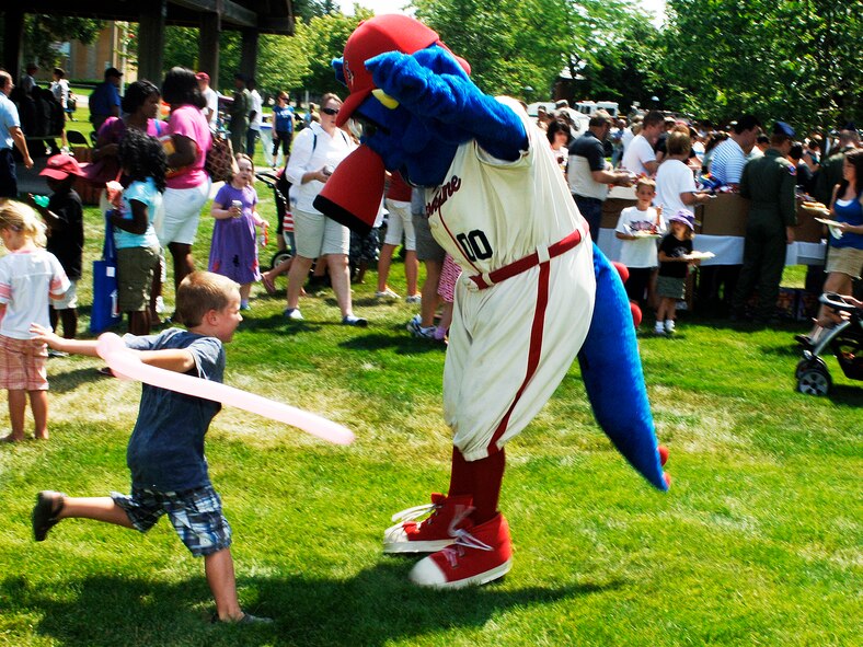 FAIRCHILD AIR FORCE BASE, Wash. –A youngster at the Base picnic fences with OTTO, the Spokane Indian’s official mascot, as well as the world’s only Spokaneasuarus, at Miller Park July 30. The picnic hosted a variety of events, including a bouncing castle, a rappelling wall, a shirt painting booth, the Air Mobility Command Icon competition, hot dogs, burgers and chicken, and many other booths and fun activities. (U.S. Air Force photo / Senior Airman Joshua K. Chapman)