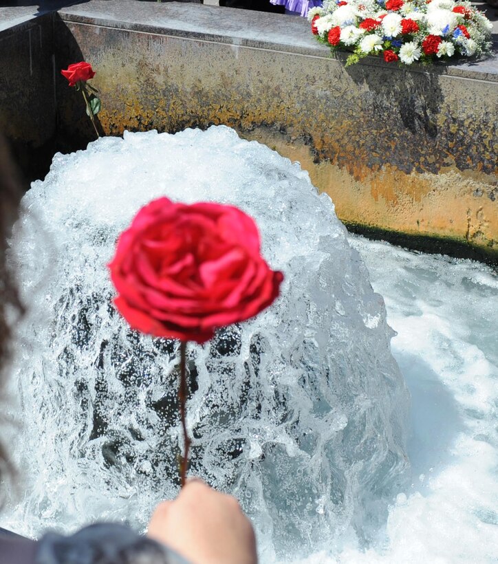 Family and friends drop roses into the Flaming Fountain at the Fallen Heroes Banner Program held at Capitol Lake in Pierre, South Dakota. The Flaming Fountain Memorial is a Veterans Memorial located on the shores of Capital Lake to honor fallen South Dakota servicemembers such as Senior Airman Jonathan Yelner of Ellsworth Air Force Base who died in April 2008. Airman Yelner and more than 20 other servicemembers were recognized during the event. (U.S. Air Force photo/Airman 1st Class Adam Grant)