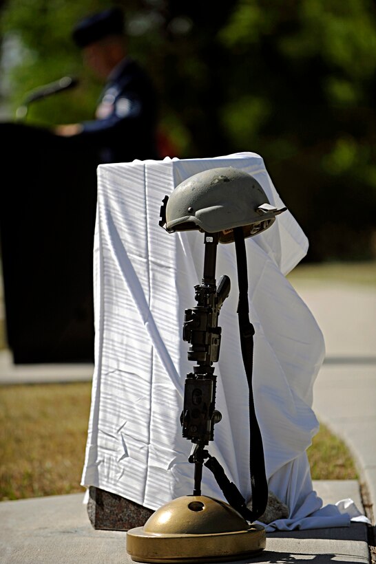 The weapon, helmet and pillar stand at Ellsworth Memorial Park while Master Sgt. Raymond Thompson, 28th Aircraft Maintenance Squadron production craftsman, narrates at a dedication ceremony honoring Senior Airman Jonathan Yelner, 28 AMXS weapons load crew member, here, August 7. Airman Yelner died in April 2008, near Bagram Air Base, Afghanistan, after receiving wounds from the explosion of an improvised explosive device. (U.S. Air Force photo/Airman 1st Class Matthew Flynn)