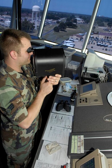 BARKSDALE AIR FORCE BASE, La. -- Senior Airman Jason Eastwood, air traffic control journeyman, flashes a green light at an inbound pilot to ensure the pilot is cleared for landing. Air traffic controllers separate and ensure the safety of air traffic. (U.S. Air Force photo by Airman 1st Class Allison M. Boehm)