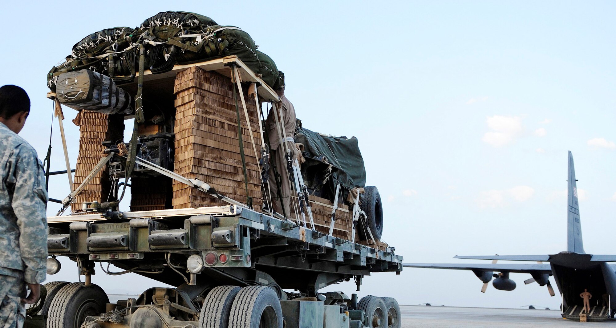 A joint Army and Air Force team loads a 10-ton pallet aboard a C-130 Hercules aircraft Aug. 8 at Bagram Airfield, Afghanistan. The total force aicrew from the 774th Expeditionary Airlift Squadron delivered an M198 howitzer artillery piece to a forward operating base in Afghanistan. The 36-foot long cannon will give troops the ability to send high-explosive shells at insurgents threatening the peace and security of the Paktika Province. (U.S. Air Force photo/Staff Sgt. Michael B. Keller)
