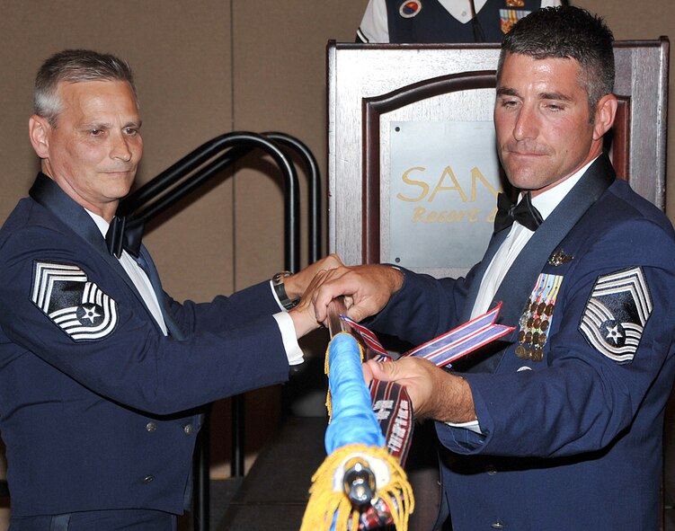 After 54 years of service, the oldest continuously-operated noncommissioned officer academy in the Air Force closed its doors July 31. Chief Master Sgt. Scott A. Kilbride, vice commandant, Barnes Center for Enlisted Education, Maxwell AFB, Ala., left, and Chief Master Sgt. Atticus Smith, Kirtland Noncommissioned Officer Academy commandant, furl the academy flag for the last time during the inactivation ceremony.  See Page 8 for more photos of the academy?s last hours. U.S. Air Force photo by Todd Berenger