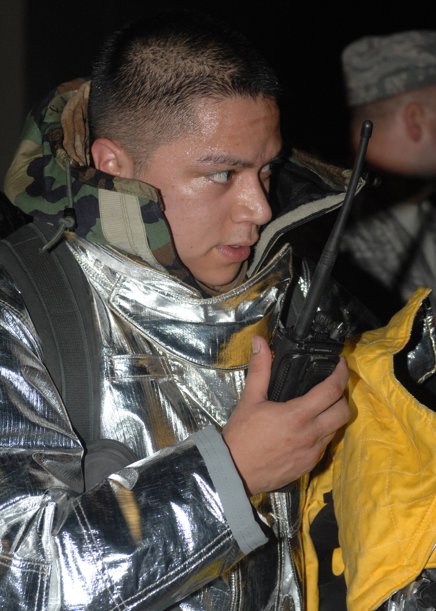 SPANGDAHLEM AIR BASE, Germany -- Staff Sgt. Roy Ramos, 52nd Civil Engineer Squadron firefighter, communicates on the radio with his team outside the 81st Fighter Squadron building during the 52nd Fighter Wing’s Phase II exercise Aug. 5. Sergeant Ramos and the rest of his team extinguished a simulated fire at the squadron after members evacuated to their alternate location following a simulated mortar attack. (U.S. Air Force photo/Senior Airman Jenifer H. Calhoun)   