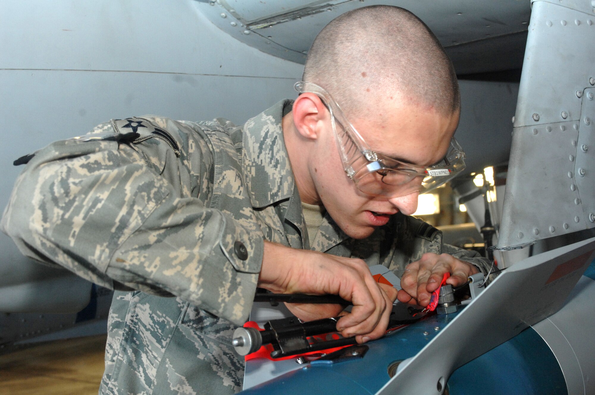 SPANGDAHLEM AIR BASE, Germany -- Airman 1st Class Ryan Isom, 52nd Aircraft Maintenance Squadron, safety wires munitions on an F-16 Fighting Falcon on the flightline during the 52nd Fighter Wing’s Phase II exercise Aug. 5. Spangdahlem Airmen used the exercise to prepare for the upcoming NATO Tactical Evaluation in June 2010. (U.S. Air Force photo/Senior Airman Jenifer H. Calhoun)   
