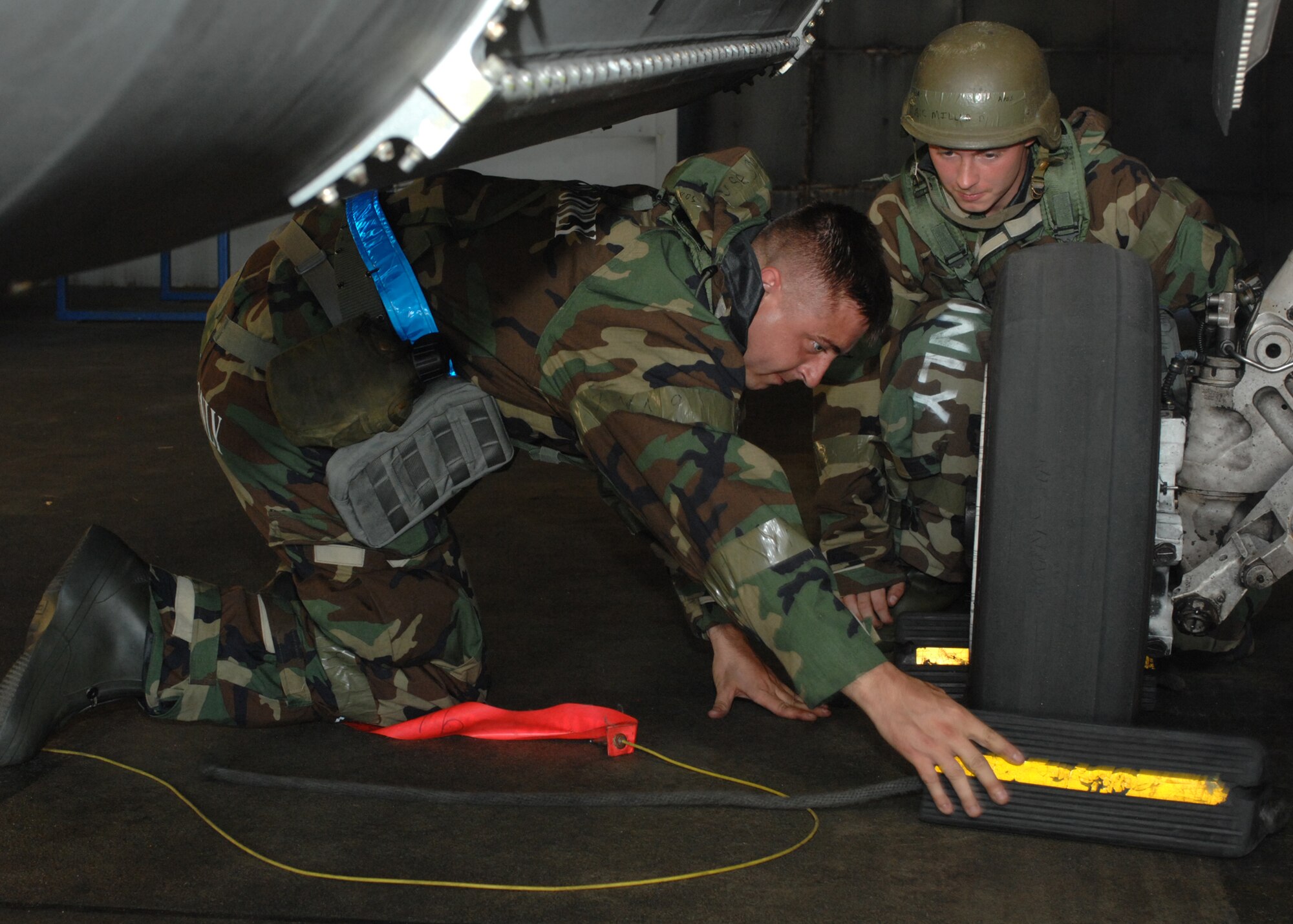 SPANGDAHLEM AIR BASE, Germany -- Staff Sgt. Derrick Farmer and Airman 1st Class David Miller, 52nd Aircraft Maintenance Squadron, secure the tires on an F-16 Fighting Falcon during the 52nd Fighter Wing’s Phase II exercise Aug. 5.  Airmen secured the tire to make sure the aircraft couldn’t roll forwards or backwards while maintainers work as the wing prepares for the NATO TACEVAL in June 2010.  (U.S. Air Force photo/Senior Airman Jenifer H. Calhoun)   