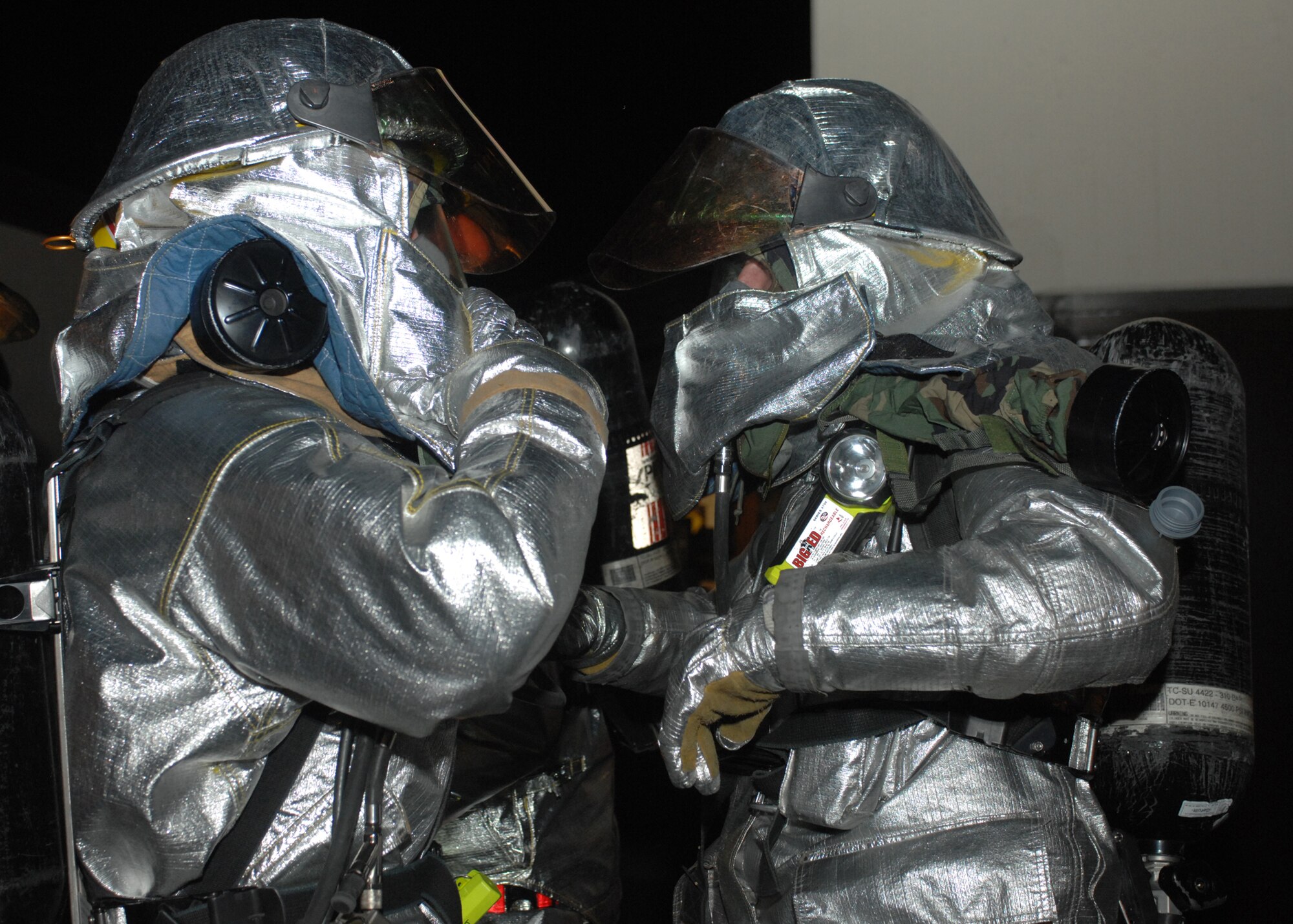 SPANGDAHLEM AIR BASE, Germany -- Firefighters from the 52nd Civil Engineer Squadron, perform buddy checks of their protective gear before responding to a simulated fire outside the 81st Fighter Squadron Aug. 5 during the 52nd Fighter Wing’s Phase II exercise.  During the exercise firefighters were required to perform their normal duties as well as emergency response in a simulated chemical environment. (U.S. Air Force photo/Senior Airman Jenifer H. Calhoun) 