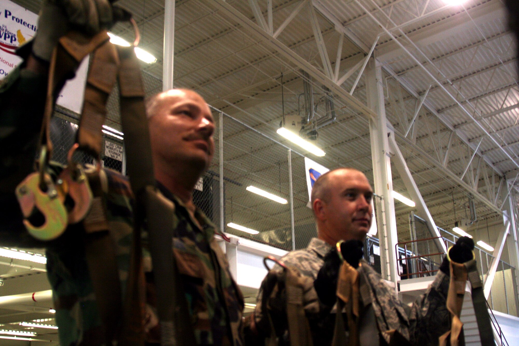Tech. Sgts. Tim Naquin and John Fetter, air transportation craftsmen for the 573rd Global Support Squadron at Travis Air Force Base, Calif., hang cargo netting at the unit's deployment warehouse Aug. 6, 2009.  The 573rd GSS is part of the 615th Contingency Response Wing at Travis AFB.  CRWs are Air Mobility Command's quick reaction force for humanitarian relief missions and for opening air bases any where in the world.  (U.S. Air Force Photo/Tech. Sgt. Scott T. Sturkol)