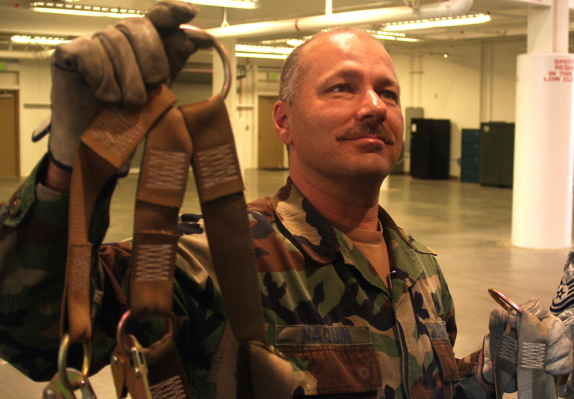 Tech. Sgt. Tim Naquin, air transportation craftsman for the 573rd Global Support Squadron at Travis Air Force Base, Calif., hangs cargo netting at the unit's deployment warehouse Aug. 6, 2009.  The 573rd GSS is part of the 615th Contingency Response Wing at Travis AFB.  CRWs are Air Mobility Command's quick reaction force for humanitarian relief missions and for opening air bases any where in the world.  (U.S. Air Force Photo/Tech. Sgt. Scott T. Sturkol)