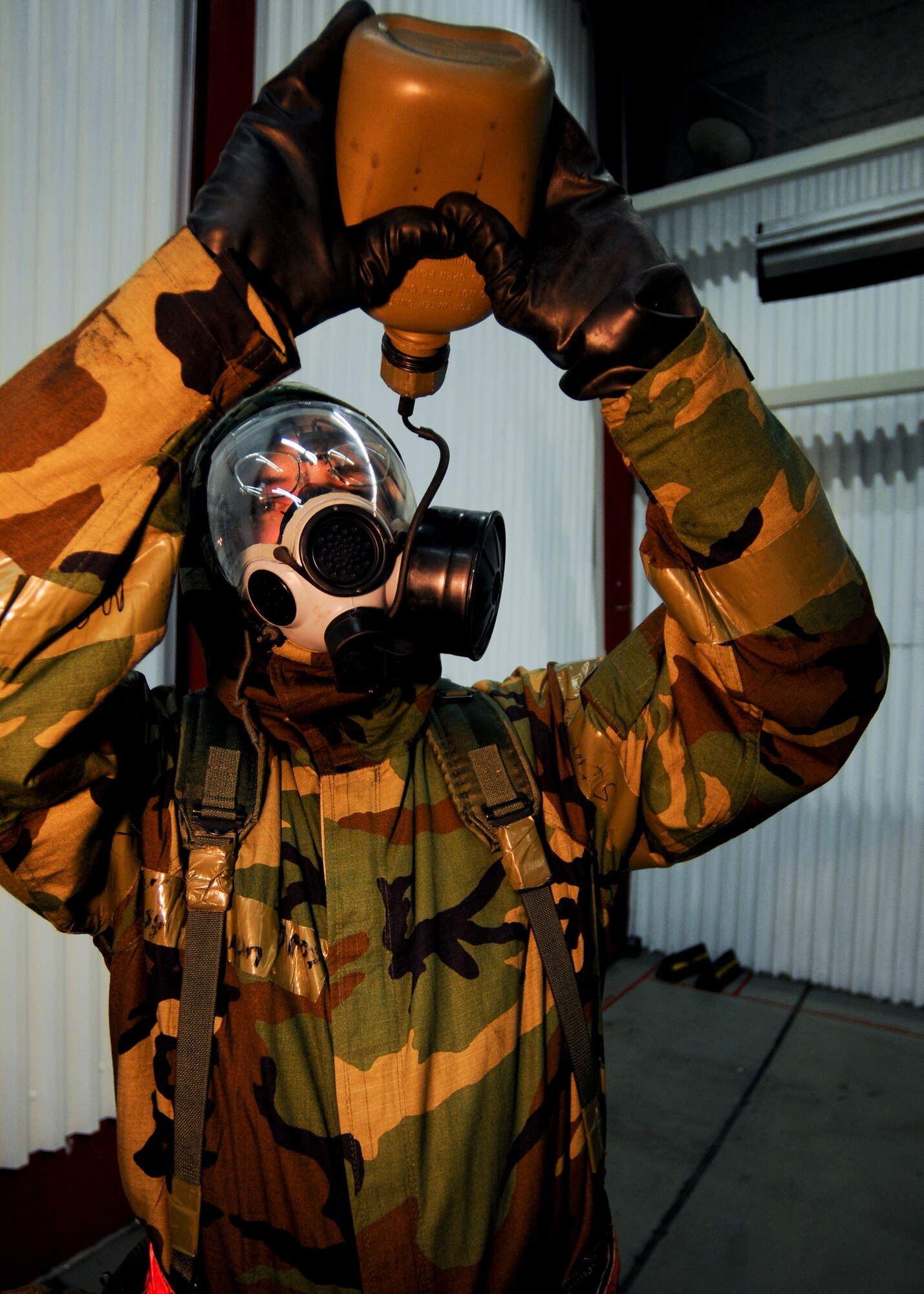 SPANGDAHLEM AIR BASE, Germany -- Staff Sgt. Louis Dymon, 52nd Equipment Maintenance Squadron, drinks from his canteen during simulated increased chemical threat conditions Aug. 6. Some members of the 52nd Fighter Wing were required to continue working while wearing protective chemical gear during the wing’s Phase II exercise Aug. 4-7. (U.S. Air Force photo/Airman 1st Class Nathanael Callon)