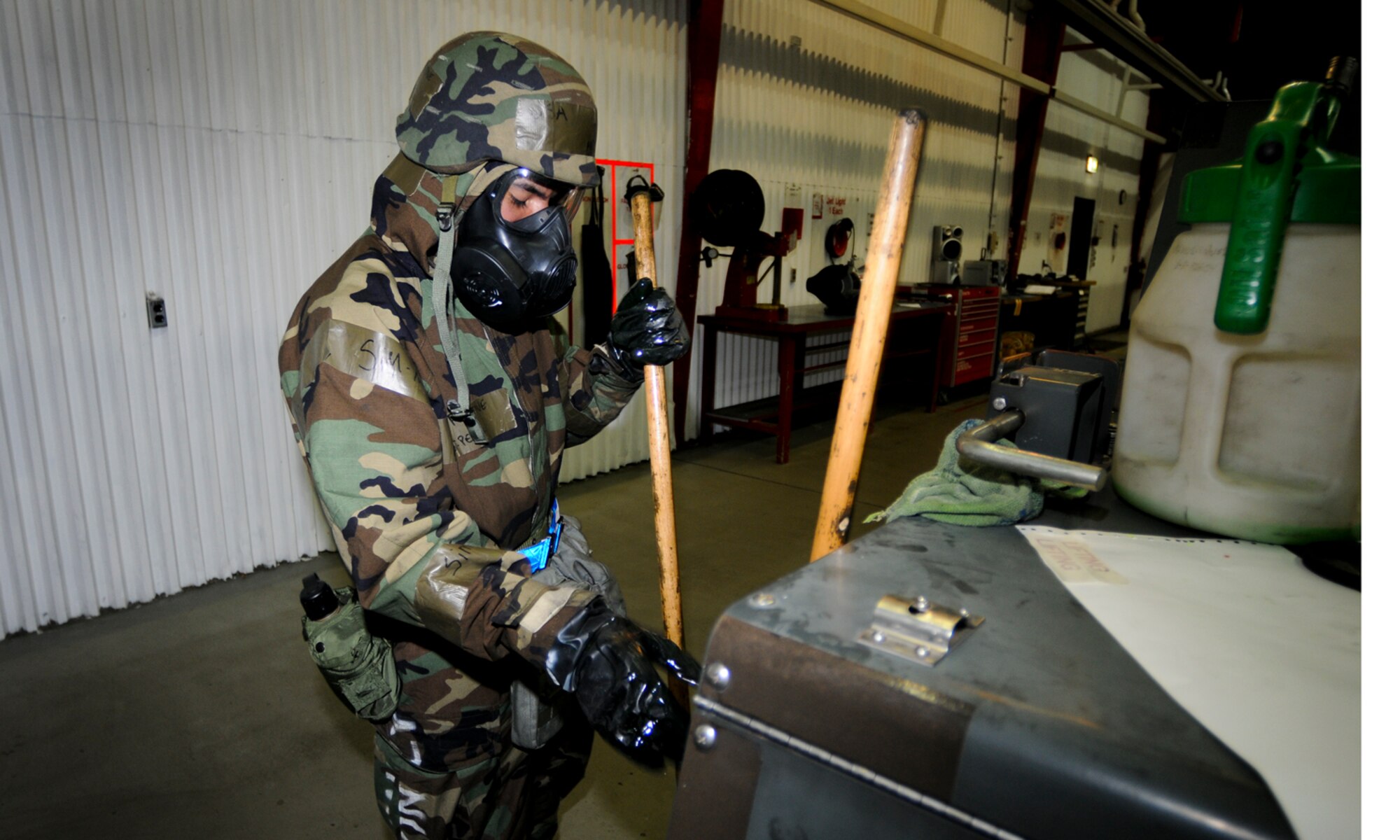 SPANGDAHLEM AIR BASE, Germany -- Airman 1st Class Jose Perez, 52nd Equipment Maintenance Squadron, cleans his work area after repairing a FL-1D flood light Aug. 6. Some members of the 52nd Fighter Wing were required to continue working while wearing protective chemical gear during the wing’s Phase II exercise Aug. 4-7. (U.S. Air Force photo/Airman 1st Class Nathanael Callon)