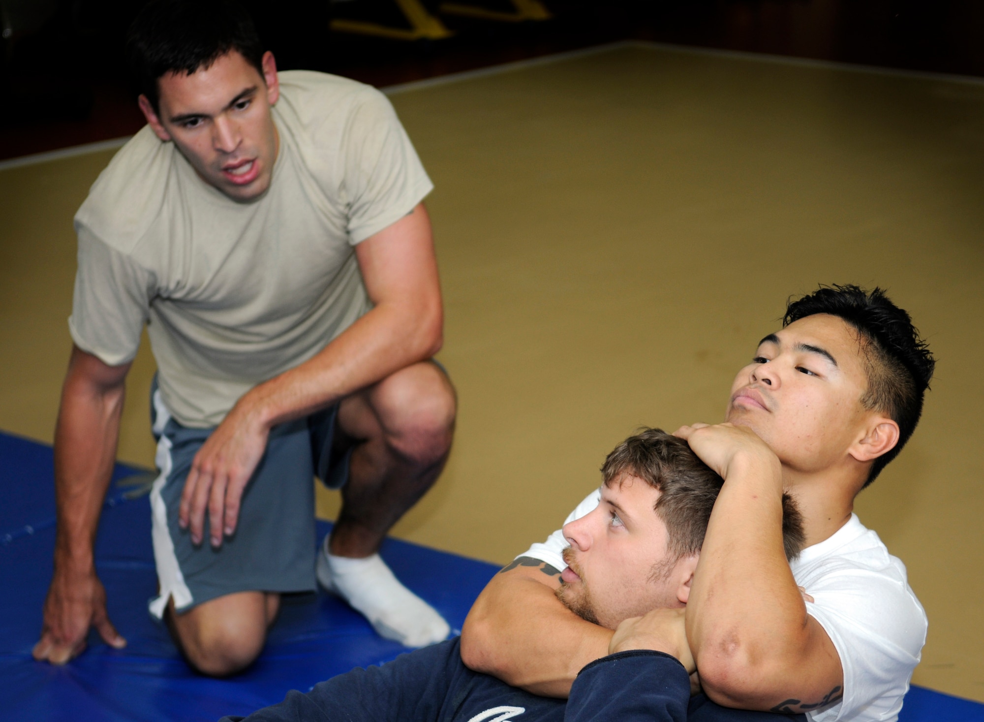 Staff Sgt. Michael Limiac, a 39th Medical Support Squadron medical information systems technician, and John Pope, husband of Staff Sgt. Lisa Pope, a 39th Air Base Wing Anti-Terrorism Force Protection specialist, demonstrate a proper rear-naked choke for Capt. Dane Franta, a 39th Comptroller Squadron budget officer, during a mixed martial arts training session Friday, Aug. 7, 2009 in the Fitness Center at Incirlik Air Base, Turkey.  Sergeant Limiac coordinates the workout sessions three times per week.  Participants of all skill levels attend the workouts and train to build on their knowledge of the sport.   More than 20 Airmen have attended the workouts since implementation.  (U.S. Air Force photo/Staff Sgt. Raymond Hoy)