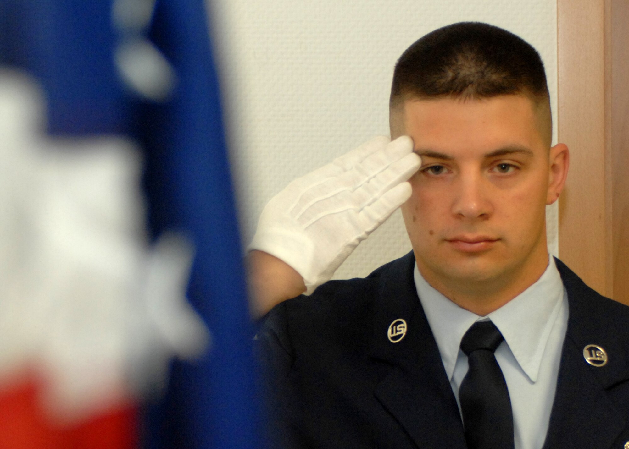 SPANGDAHLEM AIR BASE, Germany -- Staff Sgt. Justin Lemmon, 52nd Equipment Maintenance Squadron, salutes the American flag inside the 52nd Fighter Wing’s headquarters Aug. 5.  Sergeant Lemmon has been in the honor guard here for a year and half and was recently selected to be a member of the Air Force Honor Guard. He will complete three-months of technical training and go onto complete a three year controlled tour with the Air Force Honor Guard at Bolling Air Force Base, Washington, D.C., in hopes of eventually going on and performing with the Air Force Honor Guard Drill Team. (U.S. Air Force photo/Senior Airman Jenifer H. Calhoun)