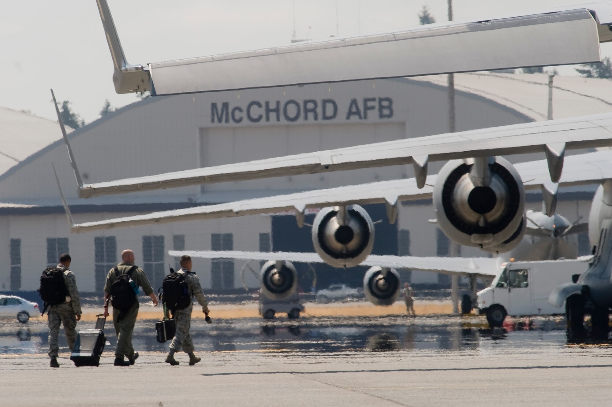 Airmen walk across the flightline during the recent heat wave. From July 27 to 29 multiple temperature records on McChord were shattered, triggering several high Heat Category warnings, causing adjustment to work/rest cycles and placing emphasis on hydration. (U.S. Air Force photo/Abner Guzman)