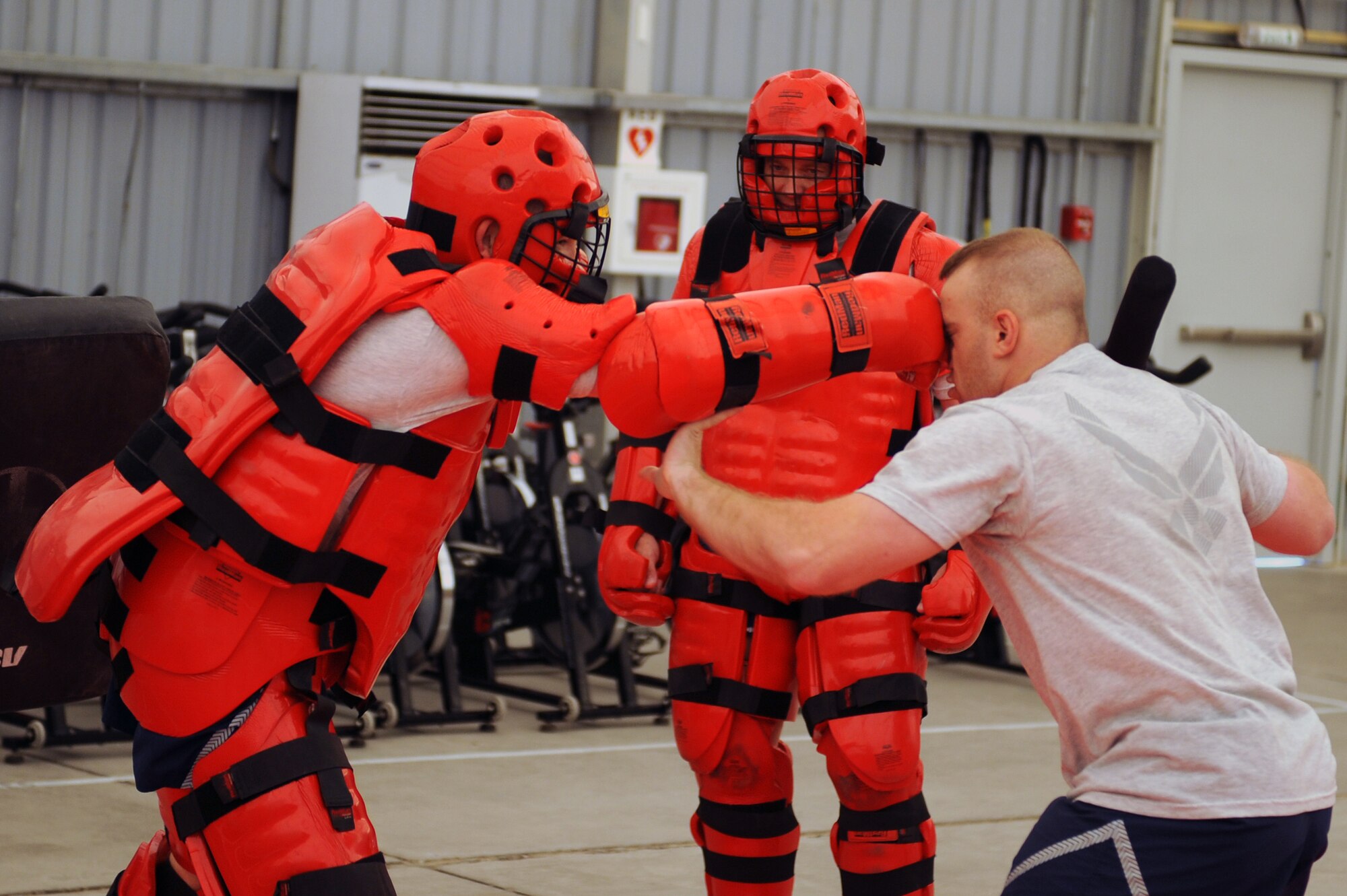 SOUTHWEST ASIA -- U.S. Air Force Tech. Sgt. Anthony Burleson, left, strikes Senior Airman Brian McLeod with a right jab during self-defense training as Col. Eric Pierce, center, observes the practice on an undisclosed base in Southwest Asia, Aug. 7, 2009. Pierce is the commander of the 380th Expeditionary Mission Support Group, and Burleson and McLeod are assigned to his unit. (U.S. Air Force photo / Tech. Sgt. Charles Larkin Sr. / Released)