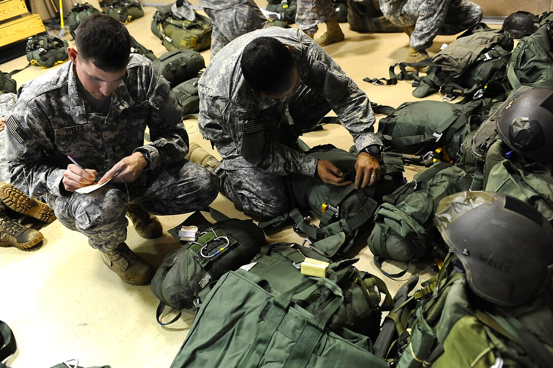 U.S. Army Rangers inspect their parachutes before a mass tactical jump during Ranger Rendezvous over Fryar Drop Zone on Fort Benning, Ga., Aug. 3, 2009.
