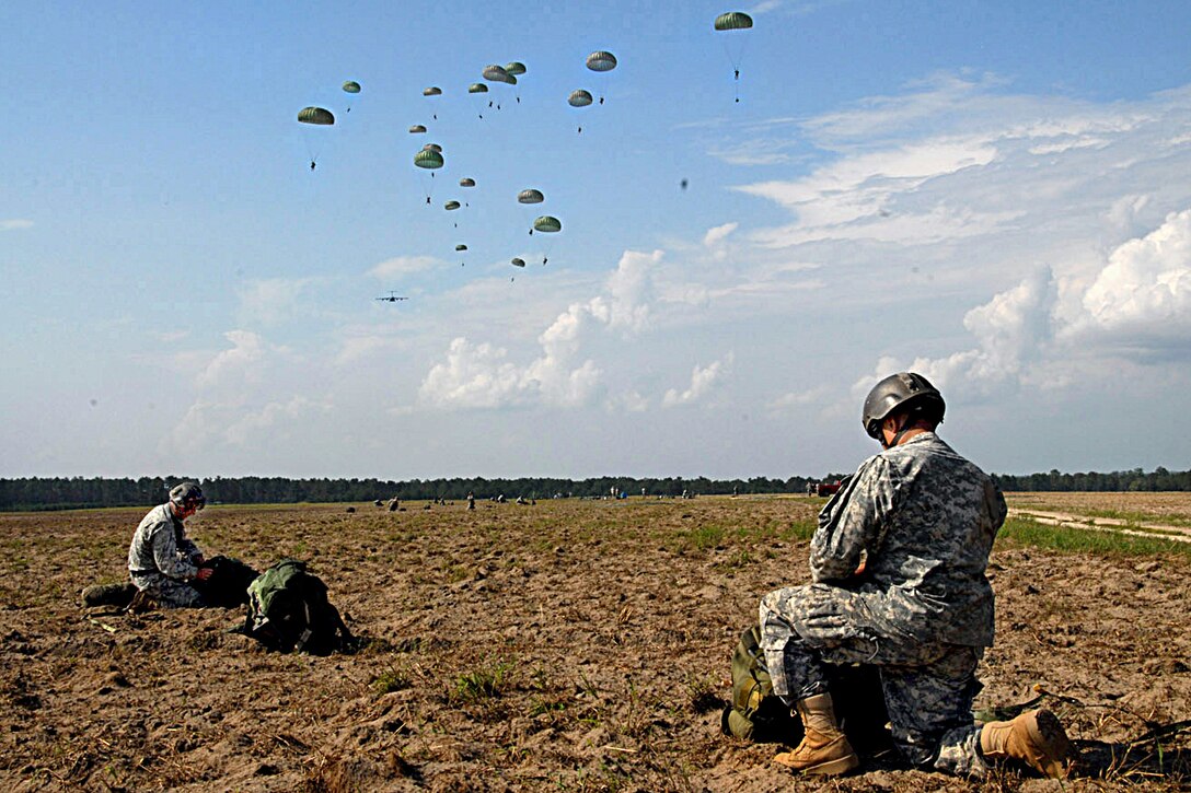 U.S Army Rangers gather their parachutes as part of a mass tactical airborne operation after landing on Fryar Drop Zone on Fort Benning, Ga.,  Aug. 3, 2009. The Rangers are assigned to the 75th Ranger Regiment. More than 1,000 Rangers from all four of the Regiment's Battalions participated in the jump, officially kicking off Ranger Rendezvous 2009.