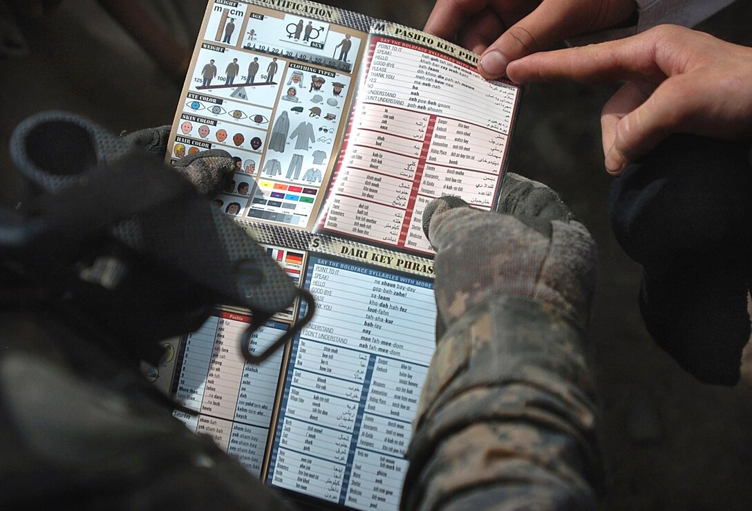 U.S. Army Staff Sgt. Jeremy Torres-Cortes points to a language translation card with the phrase “point to it” while patrolling the Wadawu valley during Operation Silver Creek in Nuristan province, Afghanistan, Aug. 7, 2009. Torres-Cortes is assigned to the 4th Infantry Division’s Headquarters Battery, 2nd Battalion, 77th Field Artillery Regiment, 4th Brigade Combat Team. U.S. troops are issued the cards, which offer basic phrases in Afghanistan's native languages, before deploying.