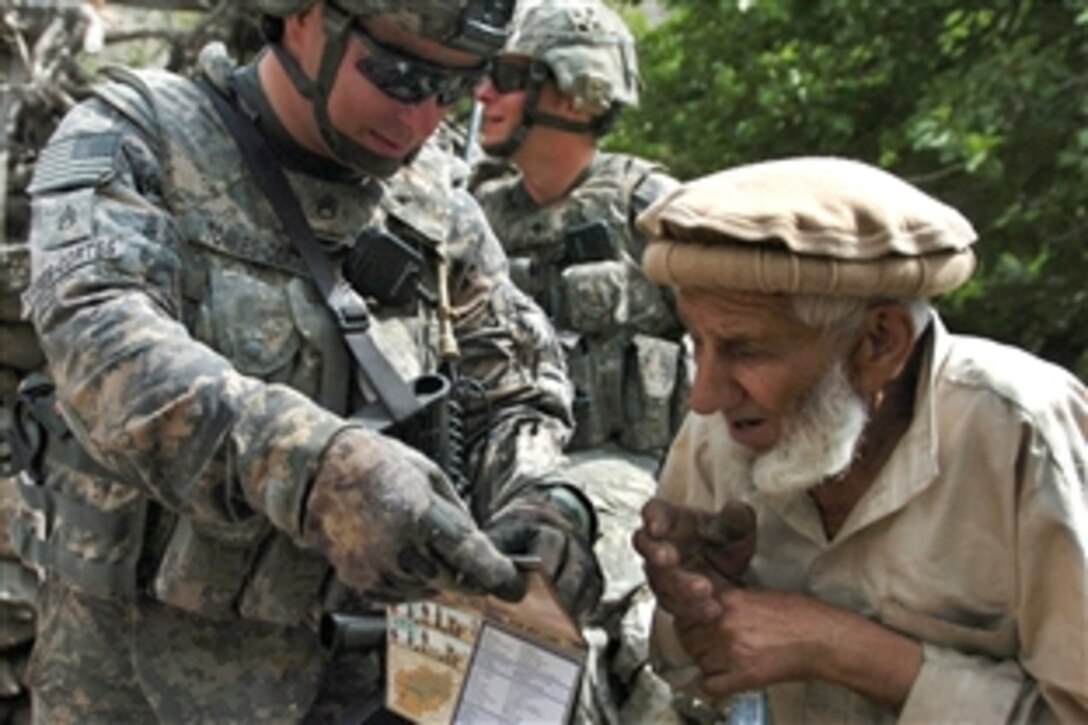 U.S. Army Staff Sgt. Jeremy Torres-Cortes tries to speak with an Afghan villager by pointing to a phrase on his language translation card while patrolling Wadawu valley in Nuristan province, Afghanistan, Aug. 7, 2009. U.S. troops are issued the cards, which offer basic phrases in Afghanistan’s native languages. Torres-Cortes is assigned to 4th Infantry Division's Headquarters Battery, 2nd Battalion, 77th Field Artillery Regiment, 4th Brigade Combat Team.