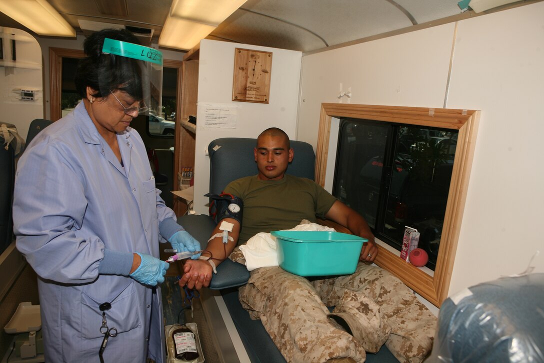 Imelda M. Leviste, a phlebotomosist with Naval Base San Diego, draws blood from Pfc. Armando M. Magana-Garibay, an aviation life support system technician with Marine Aviation Logistics Squadron 11.