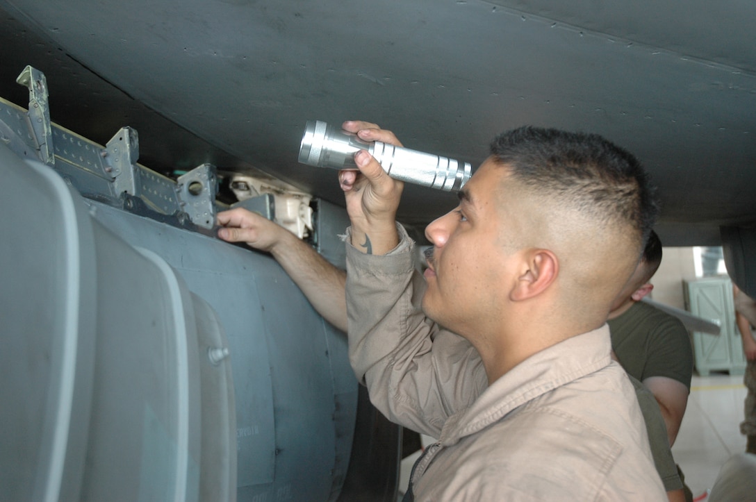 Staff Sgt. Aaron Palacios, Marine Attack Squadron 513 quality assurance inspector, checks for corrosion on an AV-8B Harrier in the squadron's hangar at the Marine Corps Air Station in Yuma, Ariz., Aug. 10, 2009. Palacios is one of approximately 150 Marines scheduled to deploy Aug. 16 and 21, 2009, in support of the 31st Marine Expeditionary Unit based in Japan. While there, the squadron is slated to participate in exercises Ryuku Warrior, Talisman Saber and Wolmi-Do Fury.::r::::n::