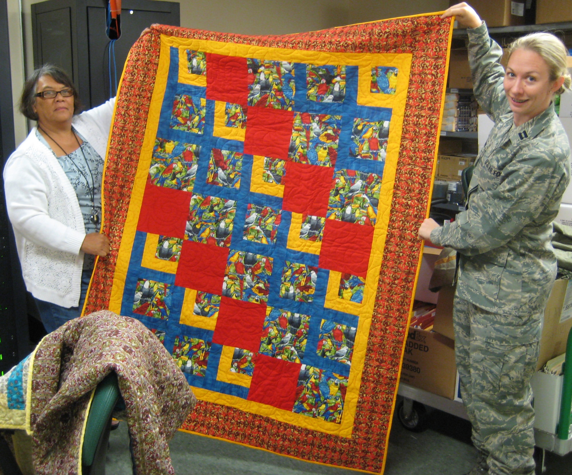 Angie Carr and Capt. Sandra Bannan display a Quilt of Valor June 12, 2009 at the Air Force Mortuary Affairs Operations Center located at Dover A.F.B., Delaware. Quilts of Valor have been awarded to several hundred workers at the center since late 2006. (U.S. Air Force photo/Tech. Sgt. Benjamin Matwey)