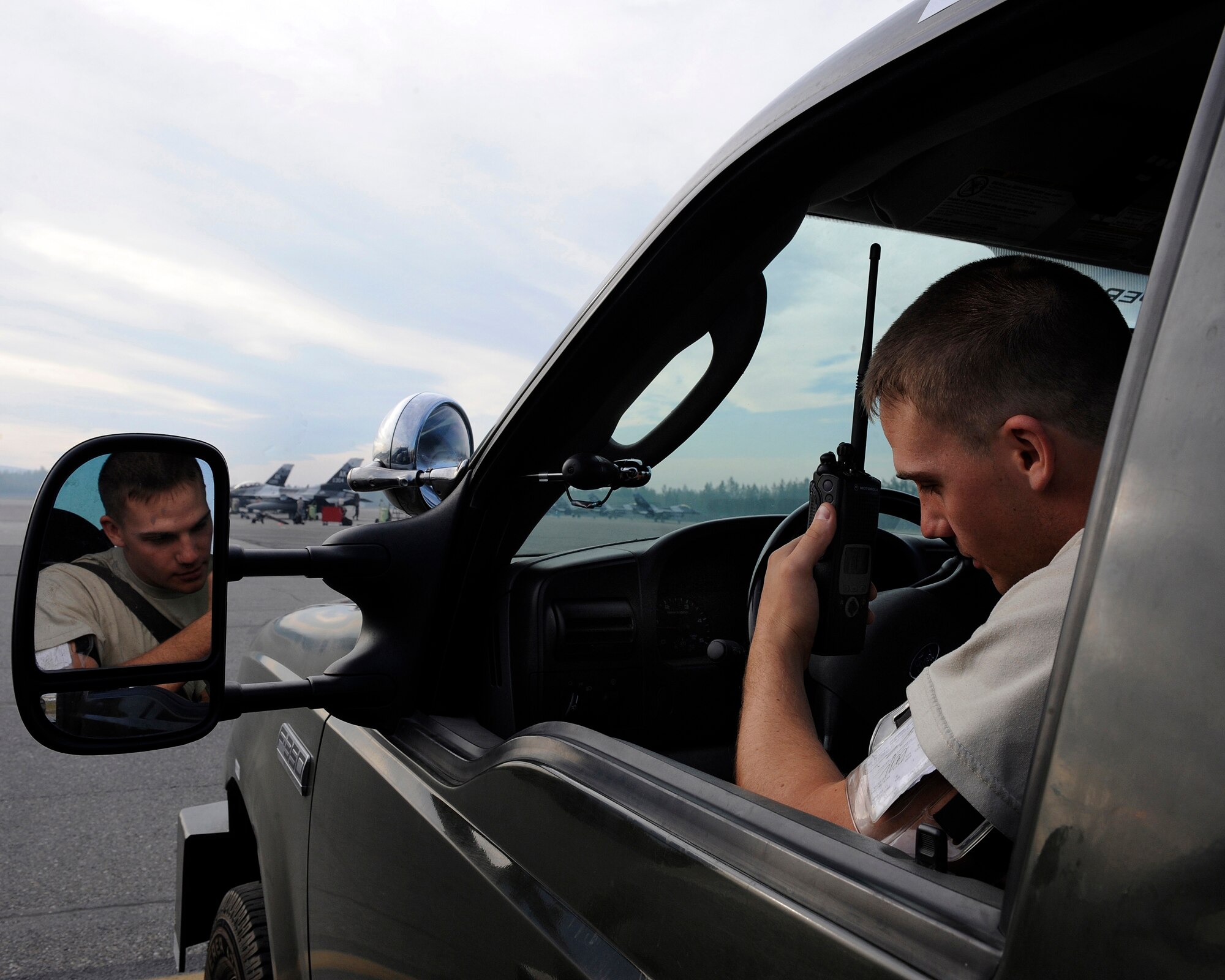 Airman Tyler Slechta waits for a radio response prior to delivering equipment to an aircraft July 31, 2009, Eielson Air Force Base, Alaska. Airman Slechta is an AGE specialist in the 354th Maintenance Squadron. (U.S. Air Force photo/Airmen 1st Class Willard E. Grande II)