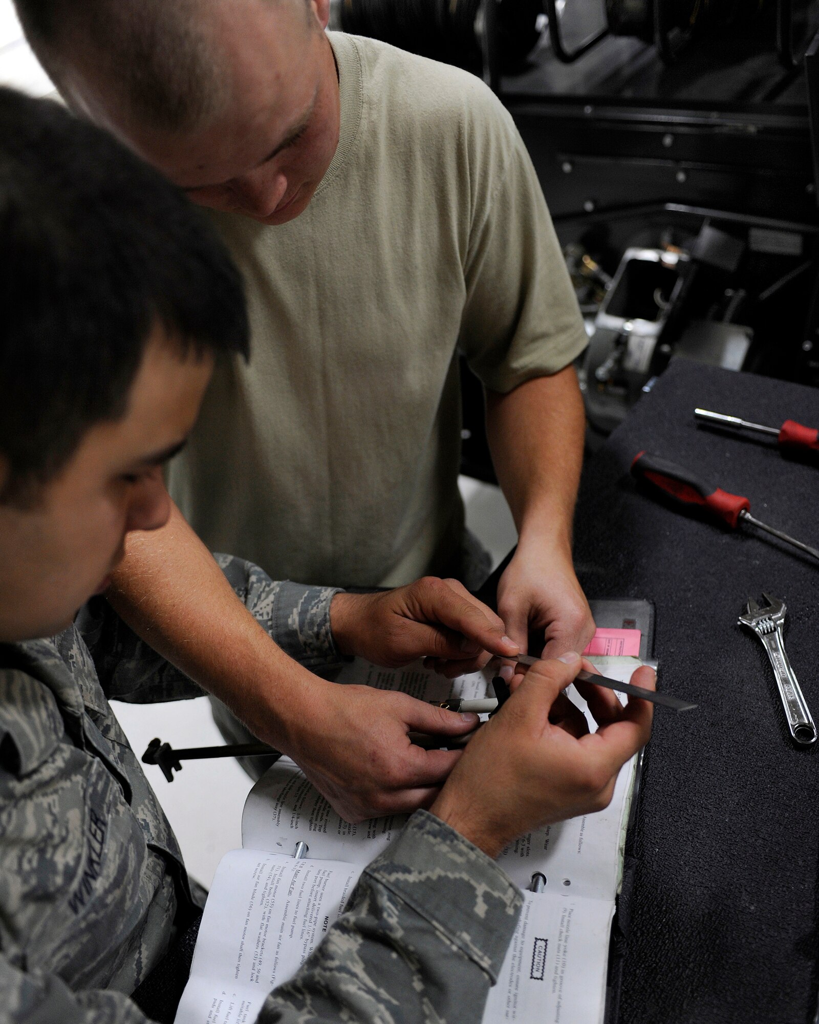 Staff Sgt. Tony Winkler and Airman 1st Class Jordan Boothe measure an ignition assembly for a NGH Heater July 31, 2009, Eielson Air force Base, Alaska. The piece must be measured accurately to ensure proper function. Both Airmen are Aerospace Ground Equipment specialists in the 354th Maintenance Squadron. (U.S. Air Force photo/Airmen 1st Class Willard E. Grande II)