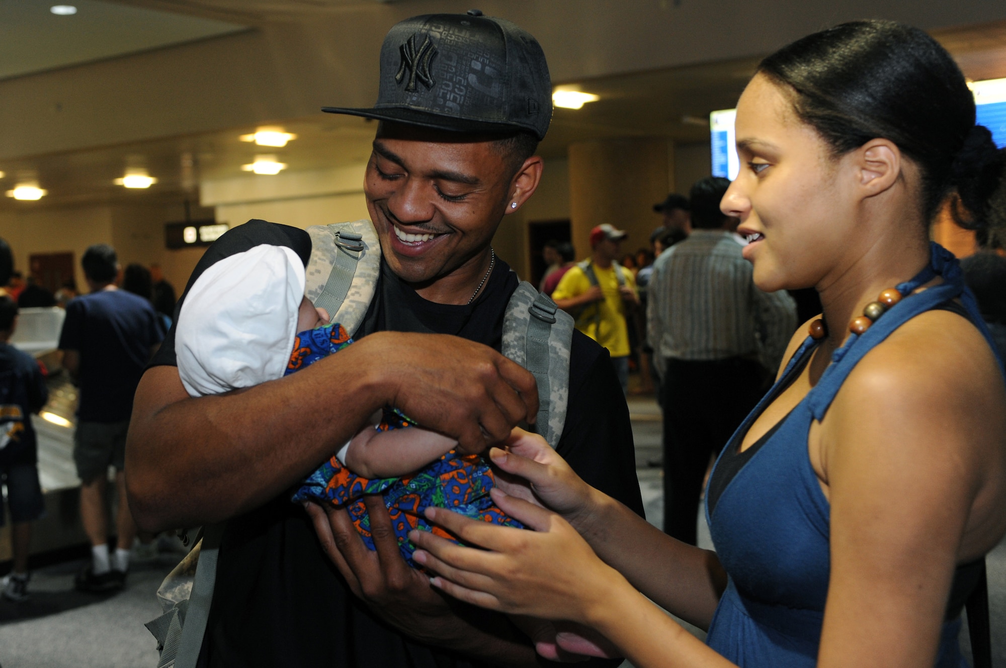 NELLIS AIR FORCE BASE, Nev. - Senior Airman Derrick Acevedo, from the 99th Security Forces Group,  smiles as he meets his 1- month-old son, Zavien, for the first time. Airman Acevedo deployed to Kuwait when his fiancee, Ms. Jasmine Fields, was four months pregnant. "This is life changing," said Airman Acevedo, when he held his son for the first time.  (U.S. Air Force photo by Tech. Sgt. Michael R. Holzworth)