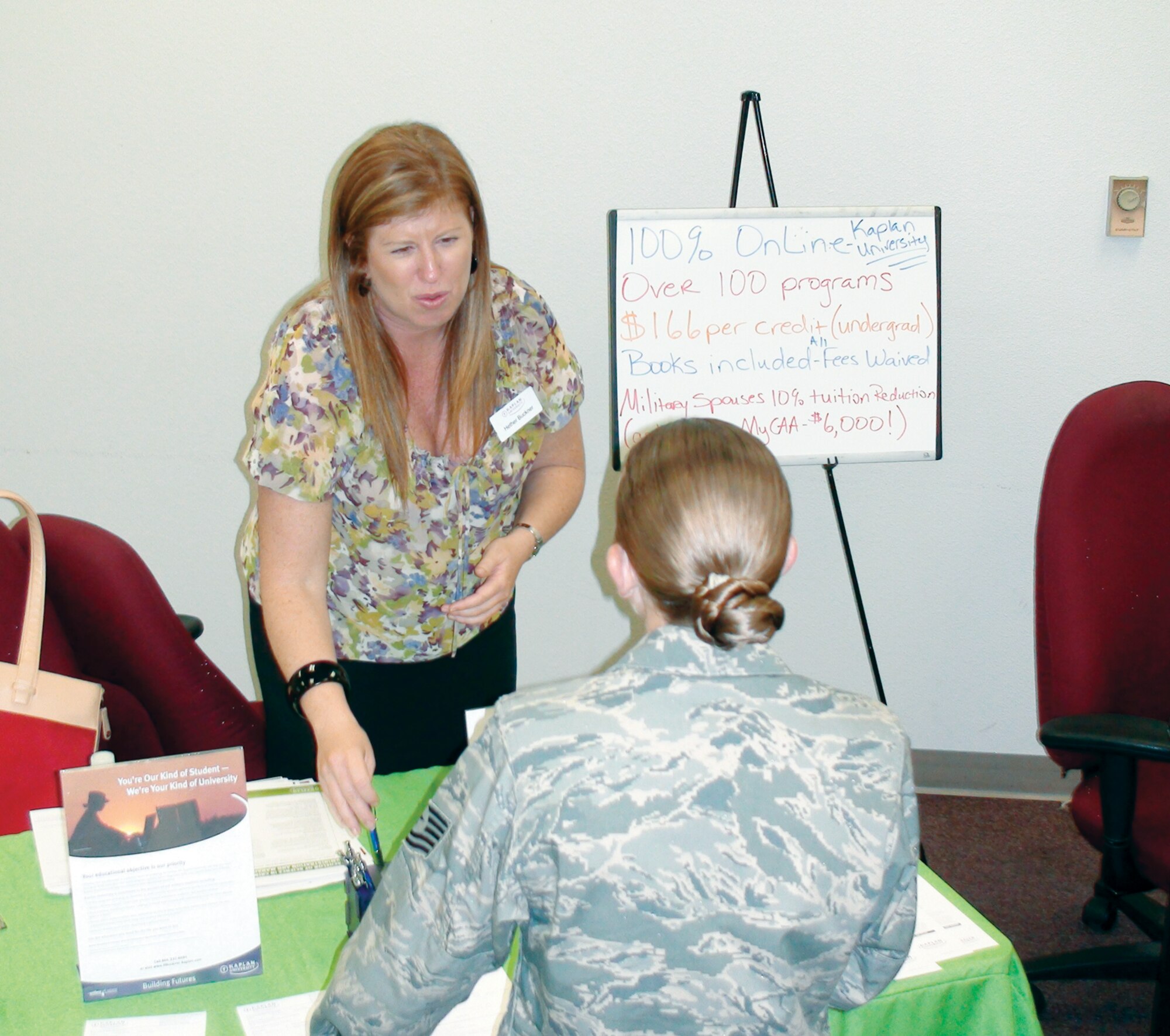 Hether Buckner (left), Education Liaison for Kaplan University, discusses Registered Nursing degree programs with Tech. Sgt. Kelly Buettner at the annual Education Fair. Approximately 50 people attended this event which followed the Community College of the Air Force graduation ceremony at March Air Reserve Base. (U.S. Air Force photo/ Master Sgt Mike Blair)