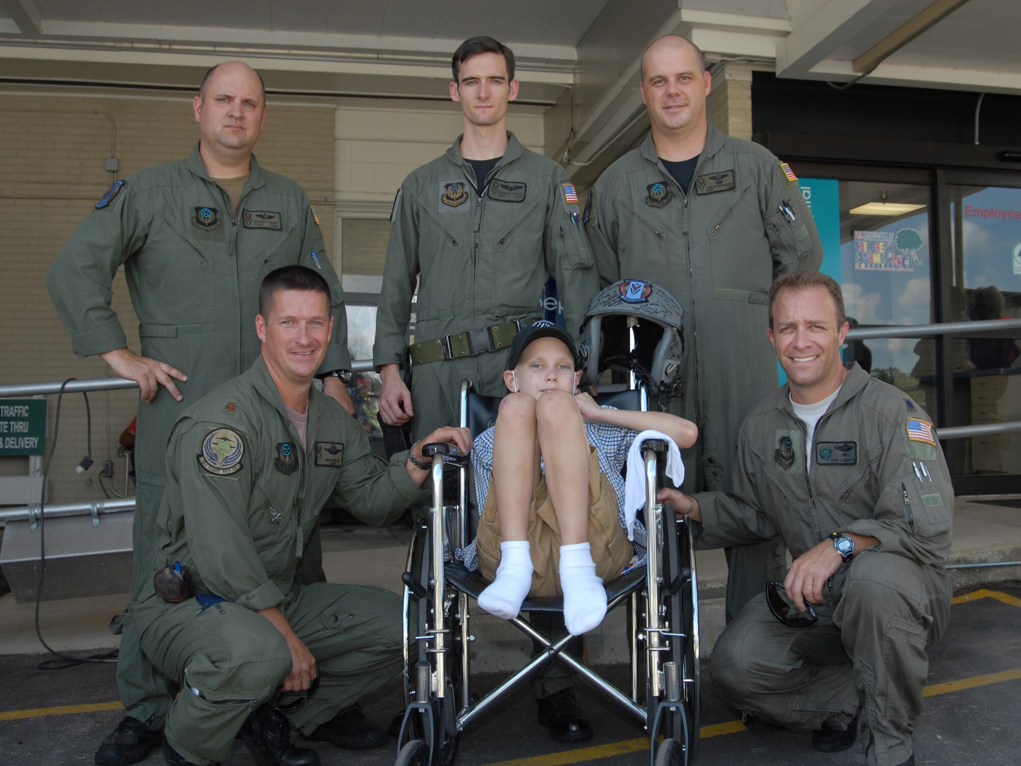 MOBILE, AL-- Christian Prockupski poses with (back; left to right)Tech. Sgt. Shawn Swift, Staff Sgt. Seamus Feeley and Tech. Sgt. John Worthington, all from the 6th Special Operations Squadron as well as (front; left to right) Maj. Brian Welch and Lt. Col. Kent Landreth, 18th Flight Test Squadron.  The crew surprised Christian by showing up to the University of Alabama Women and Children's Hospital in a UH-1 Huey helicopter, 7 Aug.  (U.S. Air Force photo by Staff Sgt. Orly N. Tyrell)