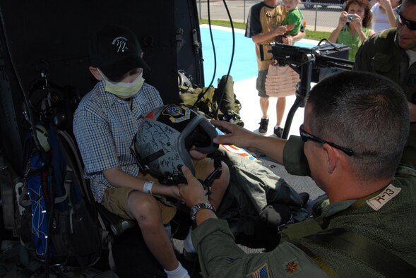 MOBILE, AL-- Maj. Brian Welch, assistant Director of Operations, 18th Flight Test Squadron, gives Christian Prockupski, a 10-year-old cancer patient, a flight helmet signed by the 1st Special Operations Wing commander, Col. Gregory Lengyel and Airmen from the 6th Special Operations Squadron and the 18th FLTS.  A few members of the 6th SOS and 18th FLTS surprised Christian at the University of Southern Alabama Women and Children's Hospital by arriving in on a UH-1 Huey helicopter. (U.S. Air Force photo by Staff Sgt. Orly N. Tyrell)