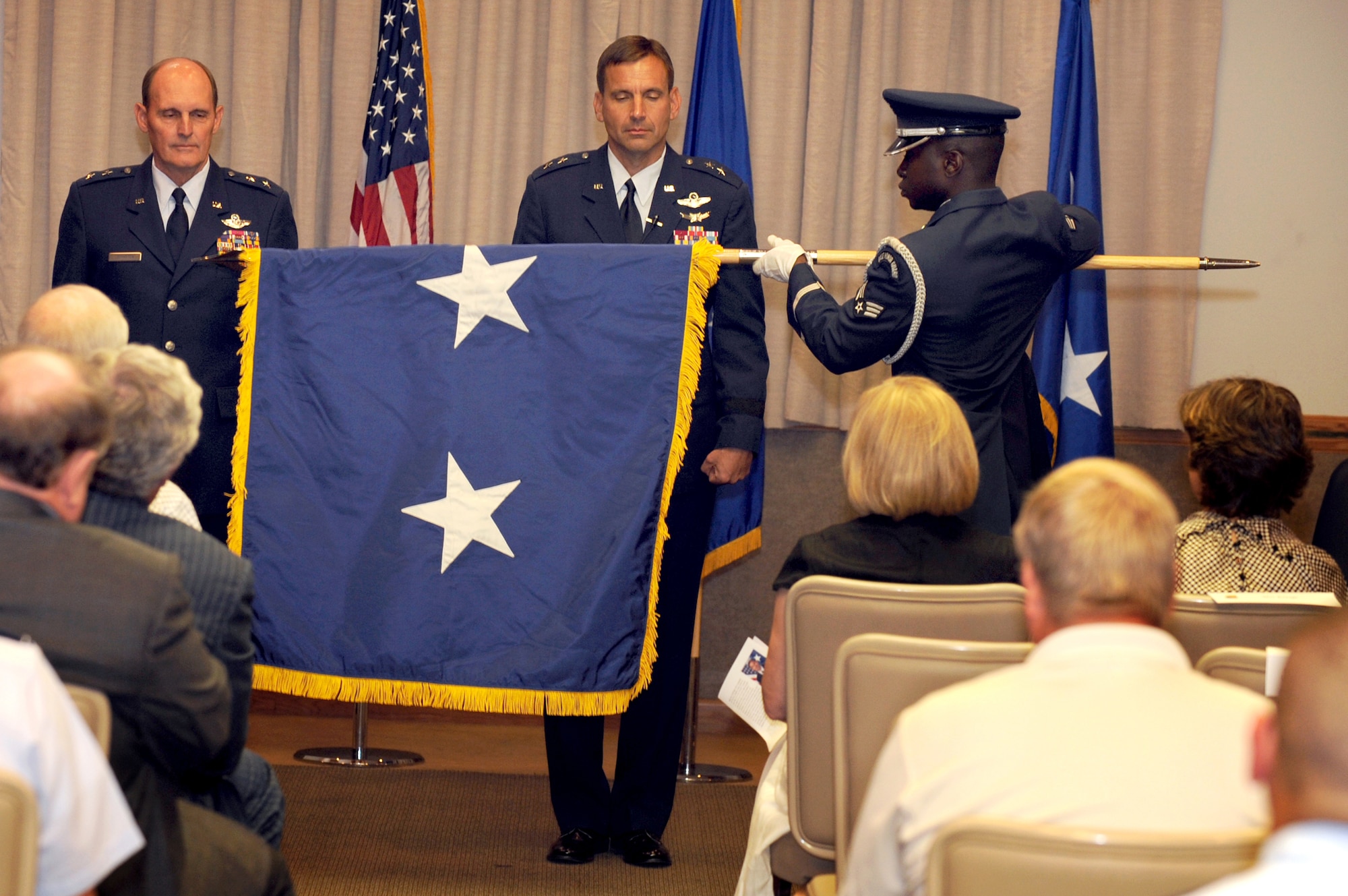 The Nellis Air Force Base honor guard and retired Maj. Gen. Lawrence Johnston, former U.S. Air Force Warfare Center commander, present newly promoted Maj. Gen. Ted Kresge, USAFWC commader, with a ceremonial two-star flag Aug. 10, Nellis Air Force Base.  The USAFWC's mission is to shape the way our force fights through operational testing, tactics development, and advanced training in air, space, and cyberspace at the operational and tactical levels.  (U.S. Air Force Photo/Tech. Sgt. Michael R. Holzworth)
