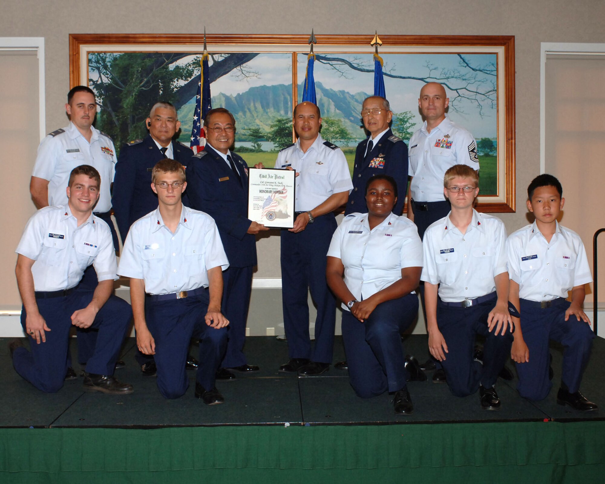HICKAM AIR FORCE BASE, Hawaii -- Hawaii Wing, Civil Air Patrol, conferred the "Honorary CAP Membership," signed by CAP National Commander, Major General Amy Courter to Colonel Giovanni Tuck, 15th Airlift Wing commander, for his outstanding support and assistance to the Civil Air Patrol at the Enlisted Club here July 31. Standing (L-R) are 1st Lt. Nathan Stickel, Maj. Steve Soeda, Col. Stan Fernandez, Col. Giovanni Tuck, Col. Herbert Kaneshige, and Command Chief Master Sgt. Craig Recker . Kneeling (L to R) are HCAP cadets Joel Ramey, Corey Trask, Imani Scott, Zechariah Trask, Kevin Cho. (U.S. Air Force photo/ Oscar A. Hernandez)