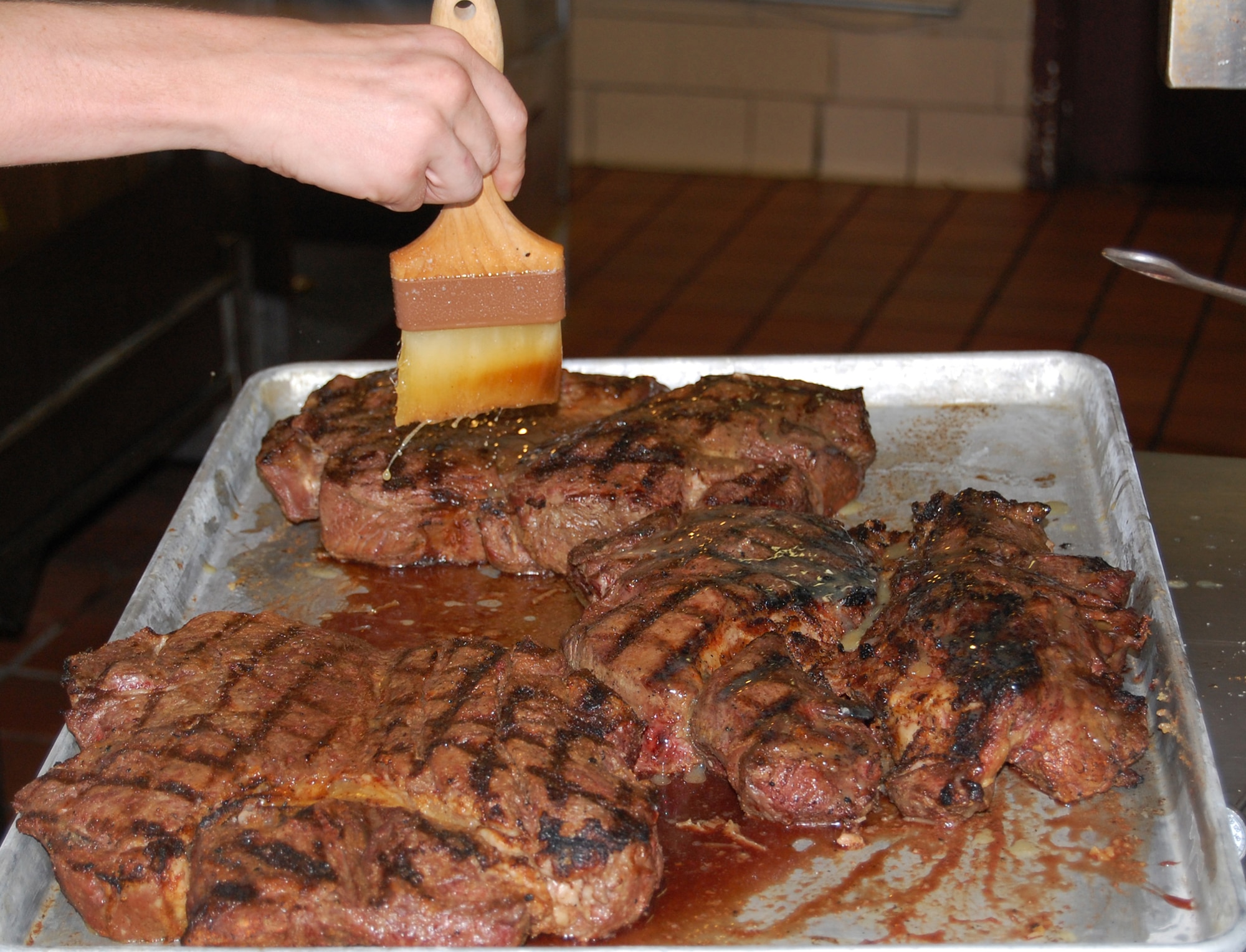 OFFUTT AIR FORCE BASE, Neb. - A 96 oz. steak is being basted in butter in preperation for the Extreme Steak Challenge Aug. 7 in the Patriot Club's MVP lounge. Contestants who were able to finish the steak, a piece of corn, a baked potato and a side salad were rewarded with $50.