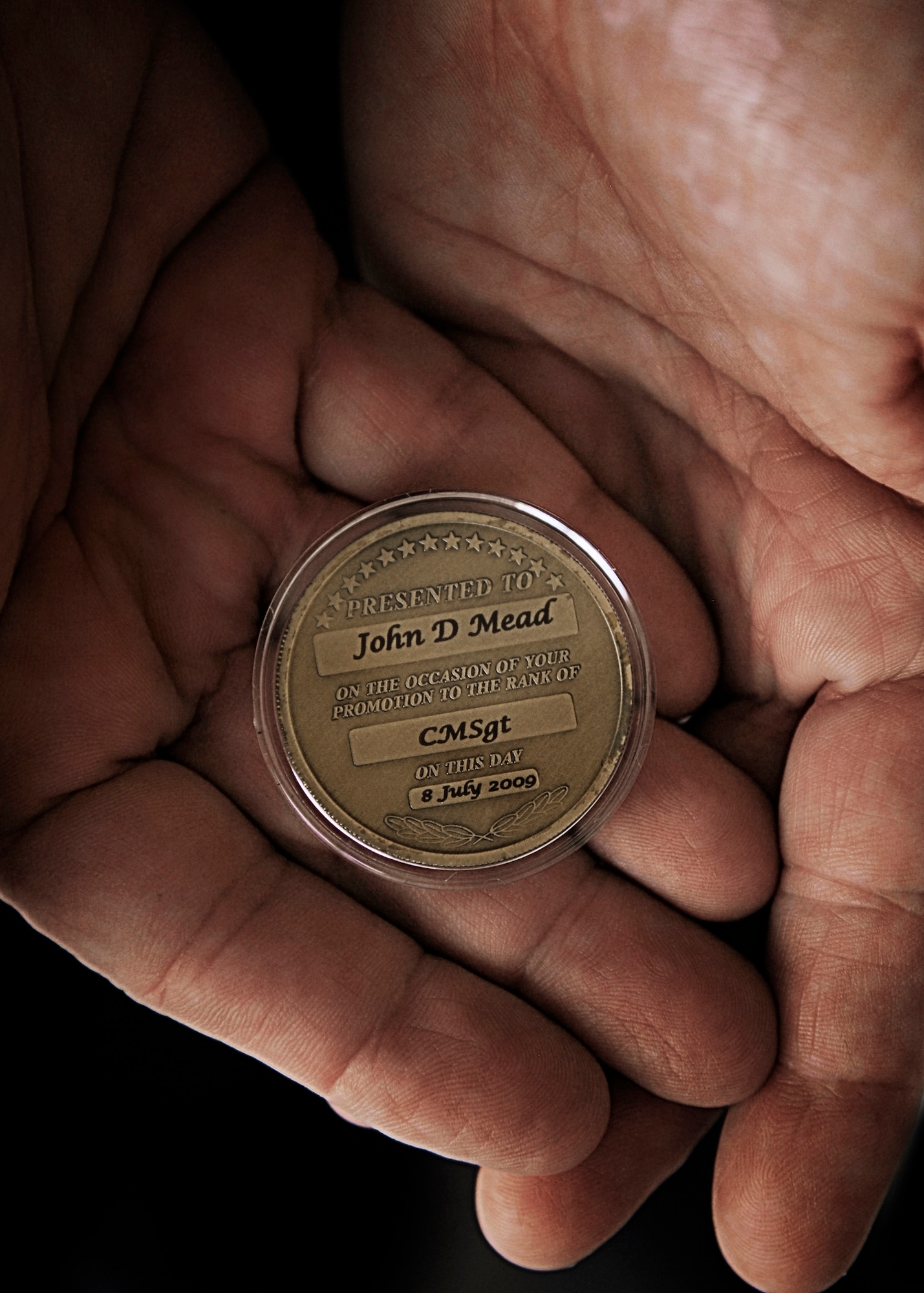 CMSgt John D. Mead, Texas Air National Guard, 149th Maintenance Operations Flight, holds the coin he was presented following his promotion to Chief Master Sergeant at Lackland Air Force Base, Texas, on August 8, 2009. (U.S. Air Force photo by Staff Sgt. Eric Wilson)(Released)