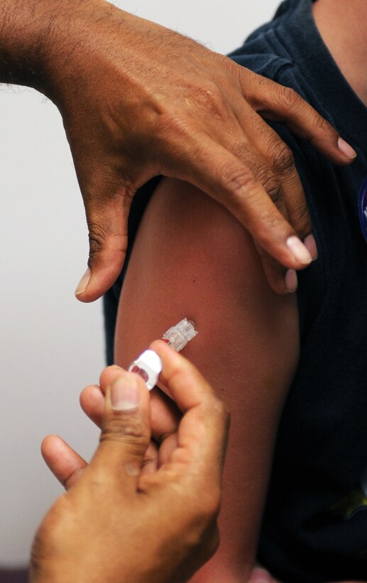 LANGLEY AIR FORCE BASE, Va. -- Master Sgt Bryan Paul, 1st Medical Operations Squadron, administers a shot to Quinton Coppola Aug. 8. Langley Hospital held a School and Sports Physicals Day to assist parents and children in getting needed immunizations before the start of the school year. (U.S. Air Force photo/Senior Airman Scott Aldridge)