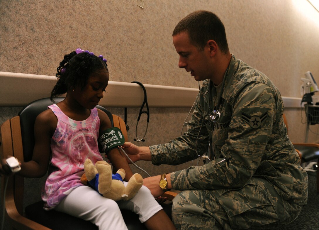 LANGLEY AIR FORCE BASE, Va. -- Airman 1st Class Jasen White, 1st Medical Operations Squadron medical technician, checks Jahniya Williams' blood pressure Aug. 8. Langley Hospital held a School and Sports Physicals day to assist parents and children in getting needed immunizations before the start of the school year. (U.S. Air Force photo/Senior Airman Scott Aldridge)