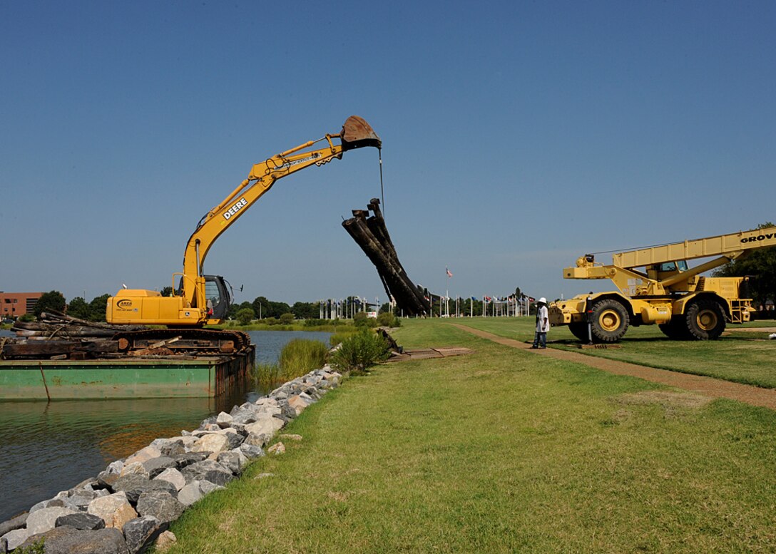LANGLEY AIR FORCE BASE, Va. -- Contractors unload logs used for the King
Street Pier off a barge and onto the Langley shore Aug. 11. The
storm-battered pier was in existence for more than 75 years until it was
officially closed to the public last September. Demolition of the pier began
recently. (U.S. Air Force photo/Airman Rebecca Montez)